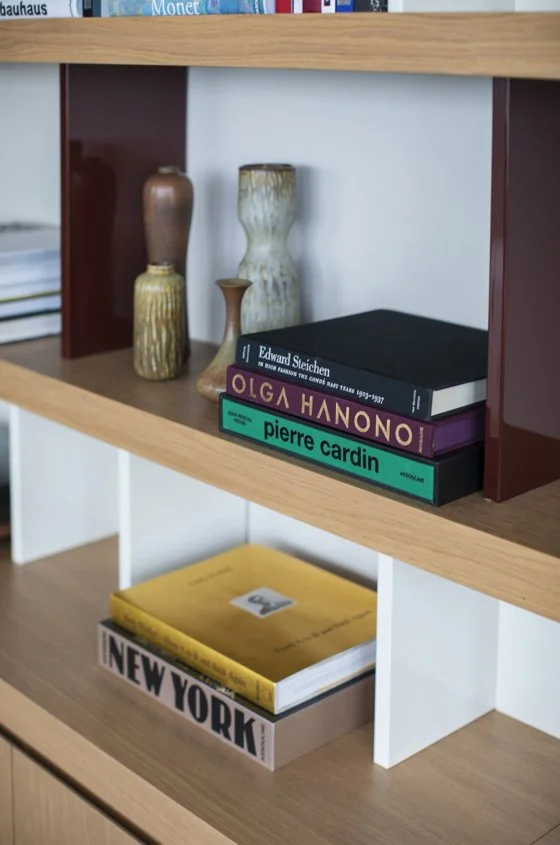 Books and vases on a wooden and white bookshelf