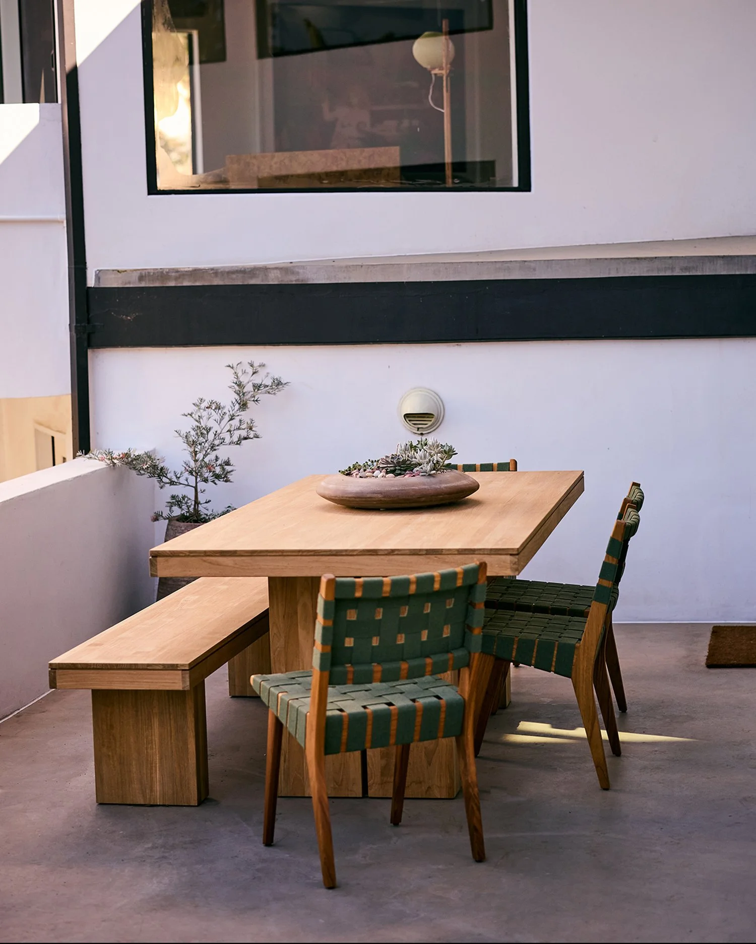 Anthony Jeselnik’s back yard, interior design by Riccio Vidaurre Design – an outdoor dining terrace features the “Kayu Teak Dining Table” paired with “Risom Dining Chairs” by Jens Risom from Design Within Reach.