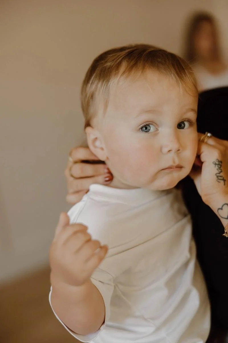Chiropractor gently supporting a toddler’s neck during a pediatric chiropractic assessment.