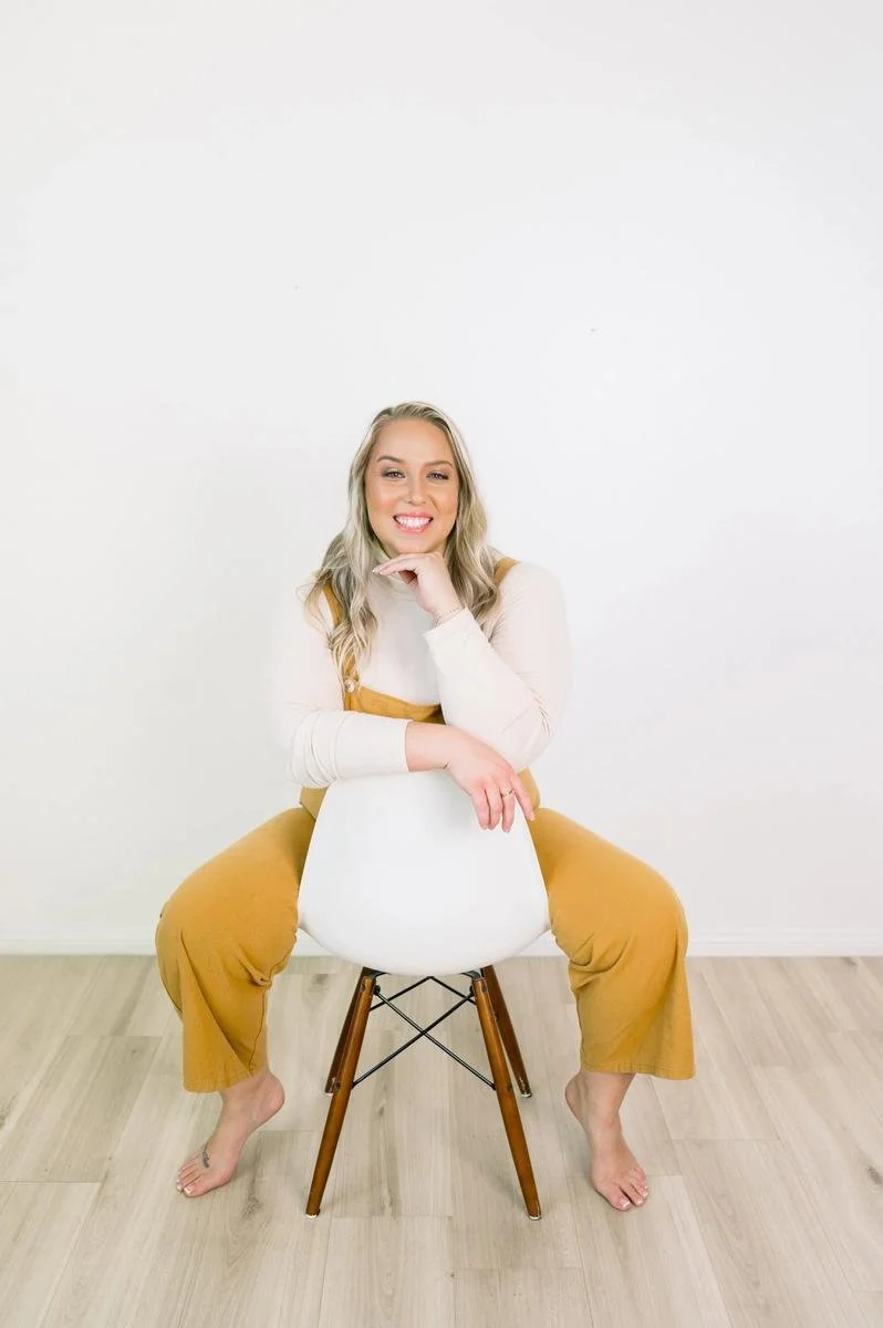 Dr. Jennifer Gordon seated on a chair for a portrait at Taproot Chiropractic.