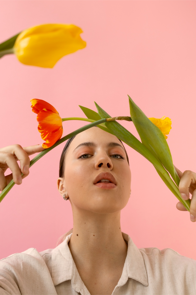 A woman holding tulips with pink background