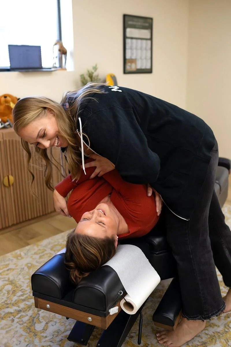 Dr. Jennifer Gordon providing a side-lying adjustment to an adult patient wearing a red shirt.