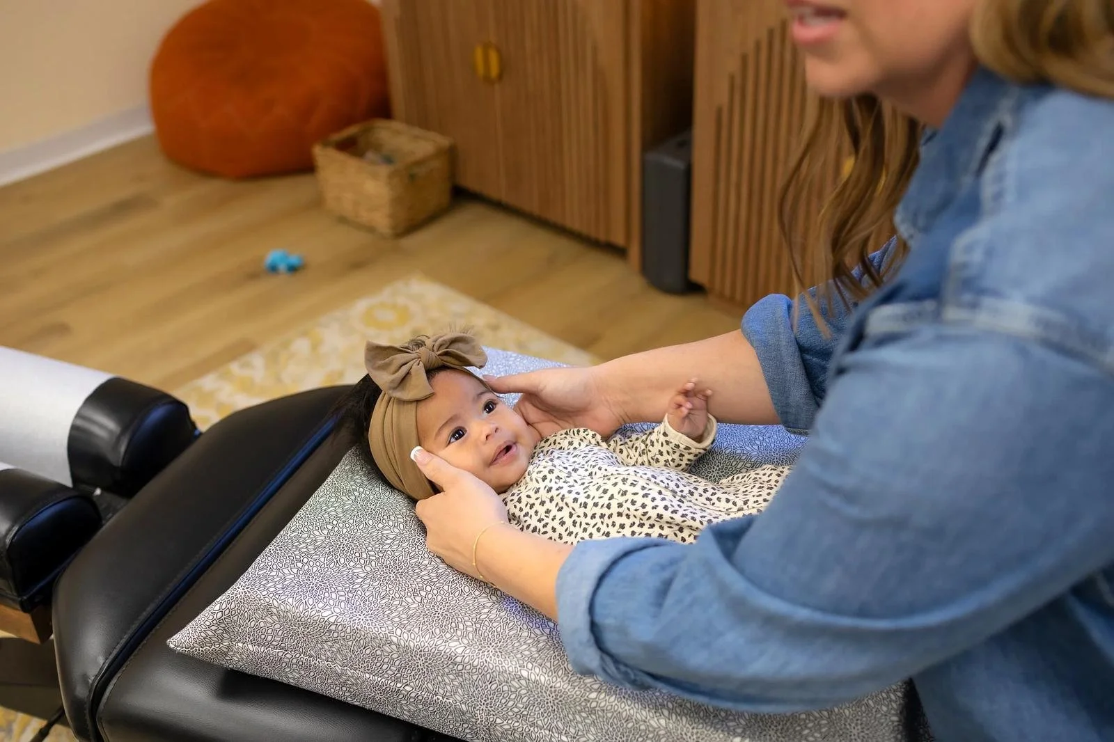An infant patient on a changing pad receiving a gentle adjustment