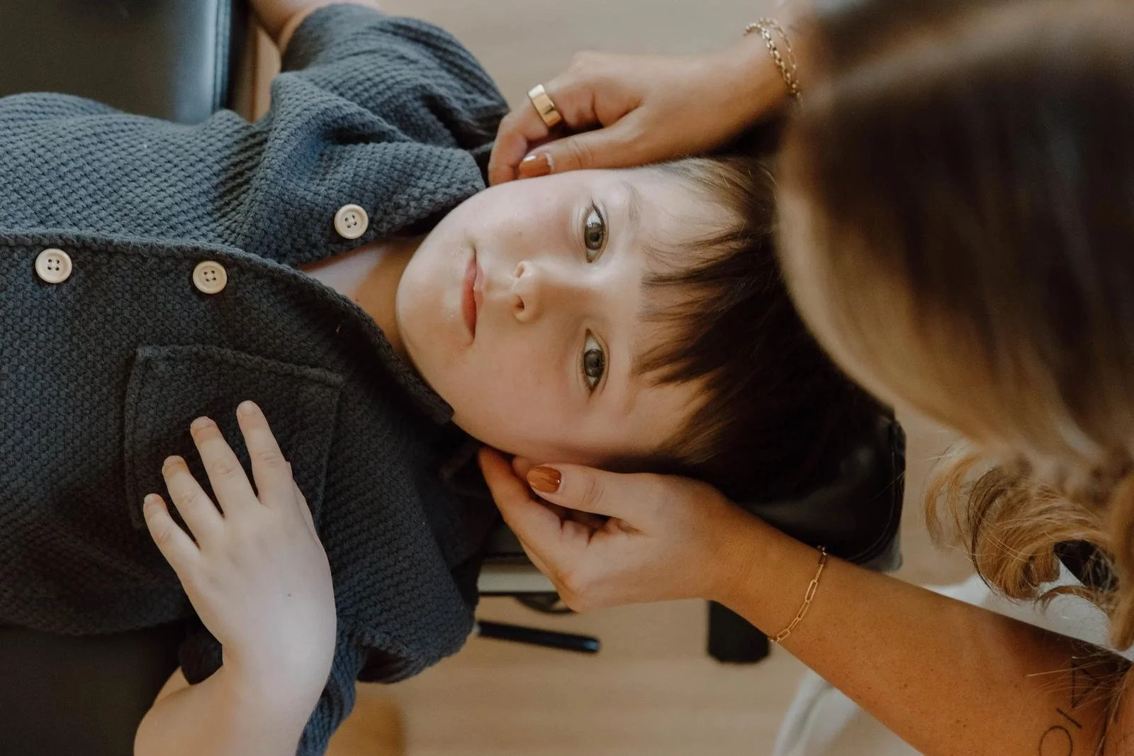Chiropractor gently supporting a child’s head and neck during a pediatric chiropractic assessment.
