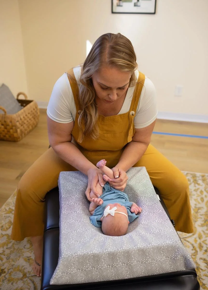 Dr. Jennifer Gordon performing an infant chiropractic adjustment at Taproot Chiropractic