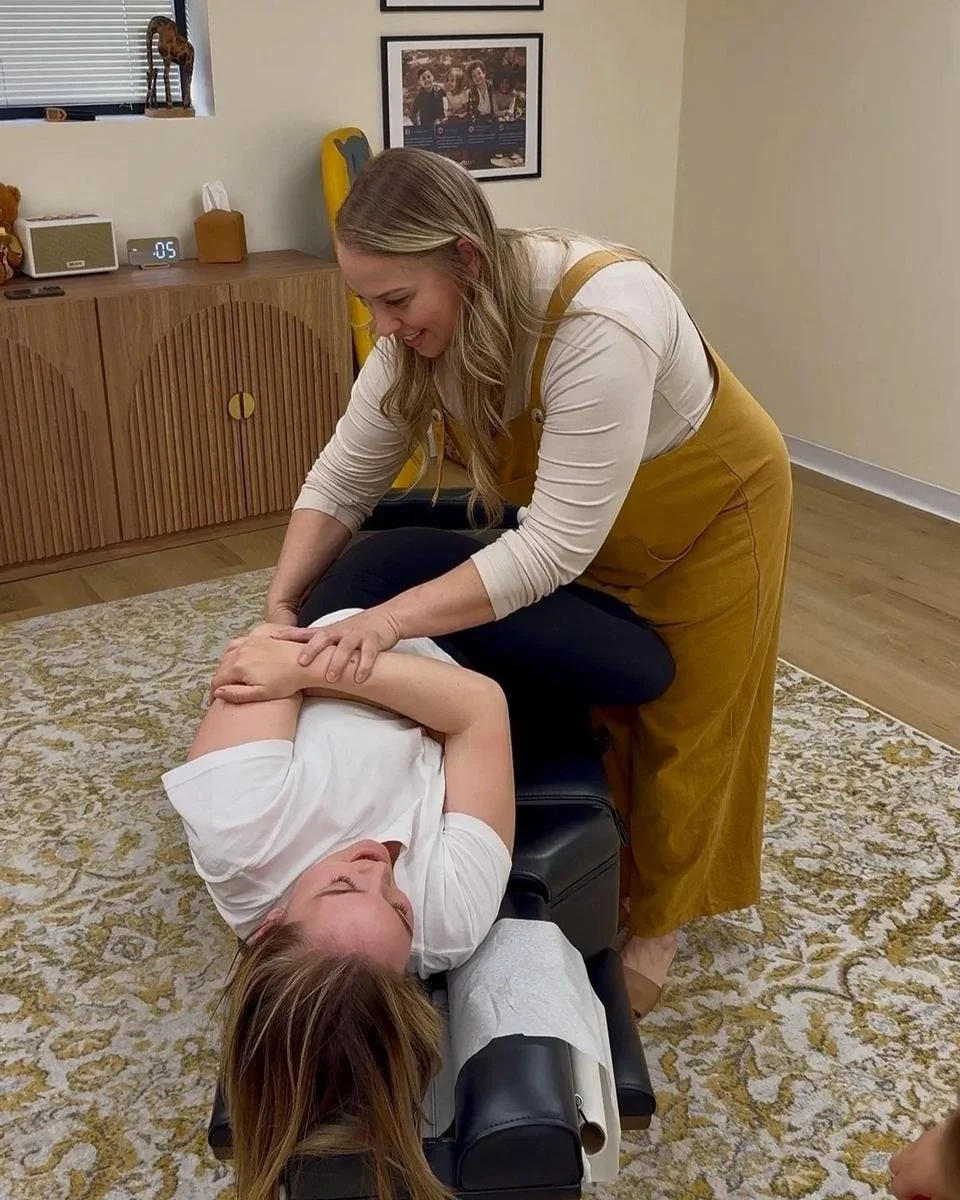 Dr. Jennifer Gordon providing a side-lying chiropractic adjustment to a patient at Taproot Chiropractic.