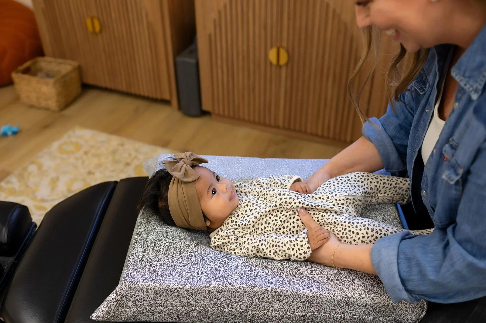 A gentle infant adjustment performed on the treatment table's changing pad