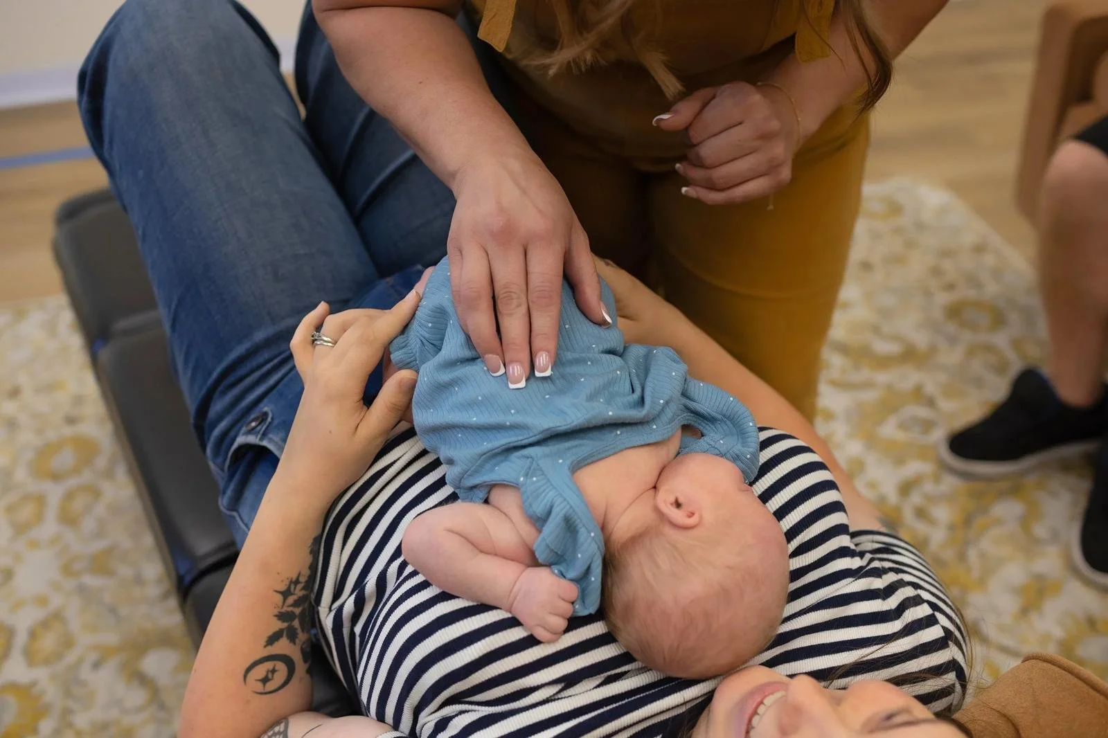 Chiropractor gently adjusting an infant resting on a parent’s chest at Taproot Chiropractic.