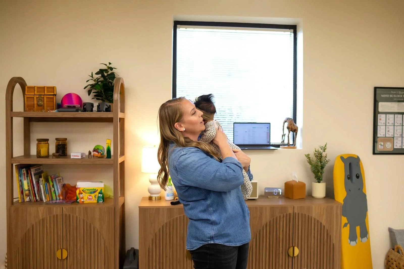 Dr. Jennifer Gordon holding an infant upright in the pediatric treatment room at Taproot Chiropractic.