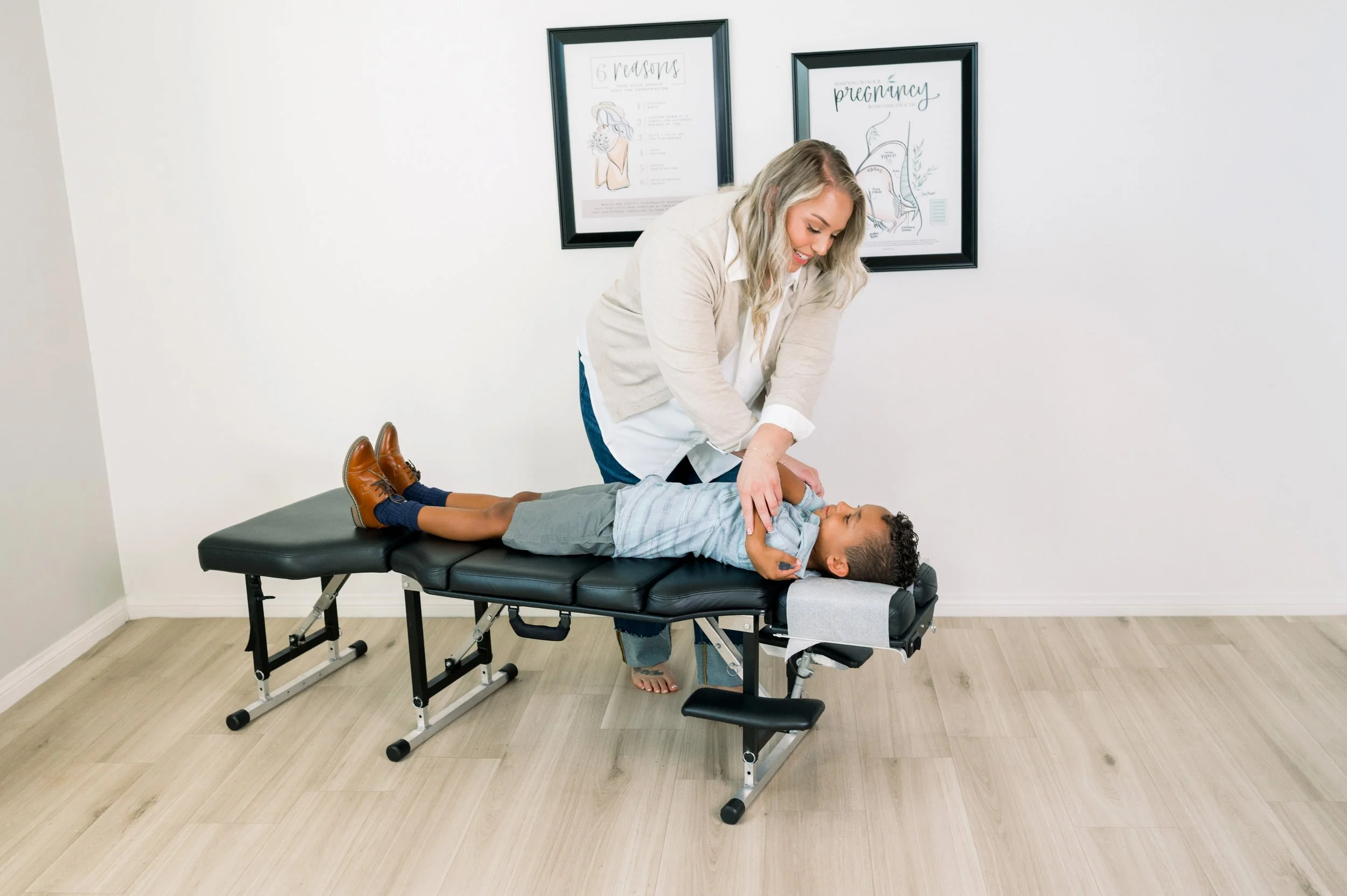 A chiropractor adjusting a young boy lying on a chiropractic table in a chiropractic office in Temecula, CA.