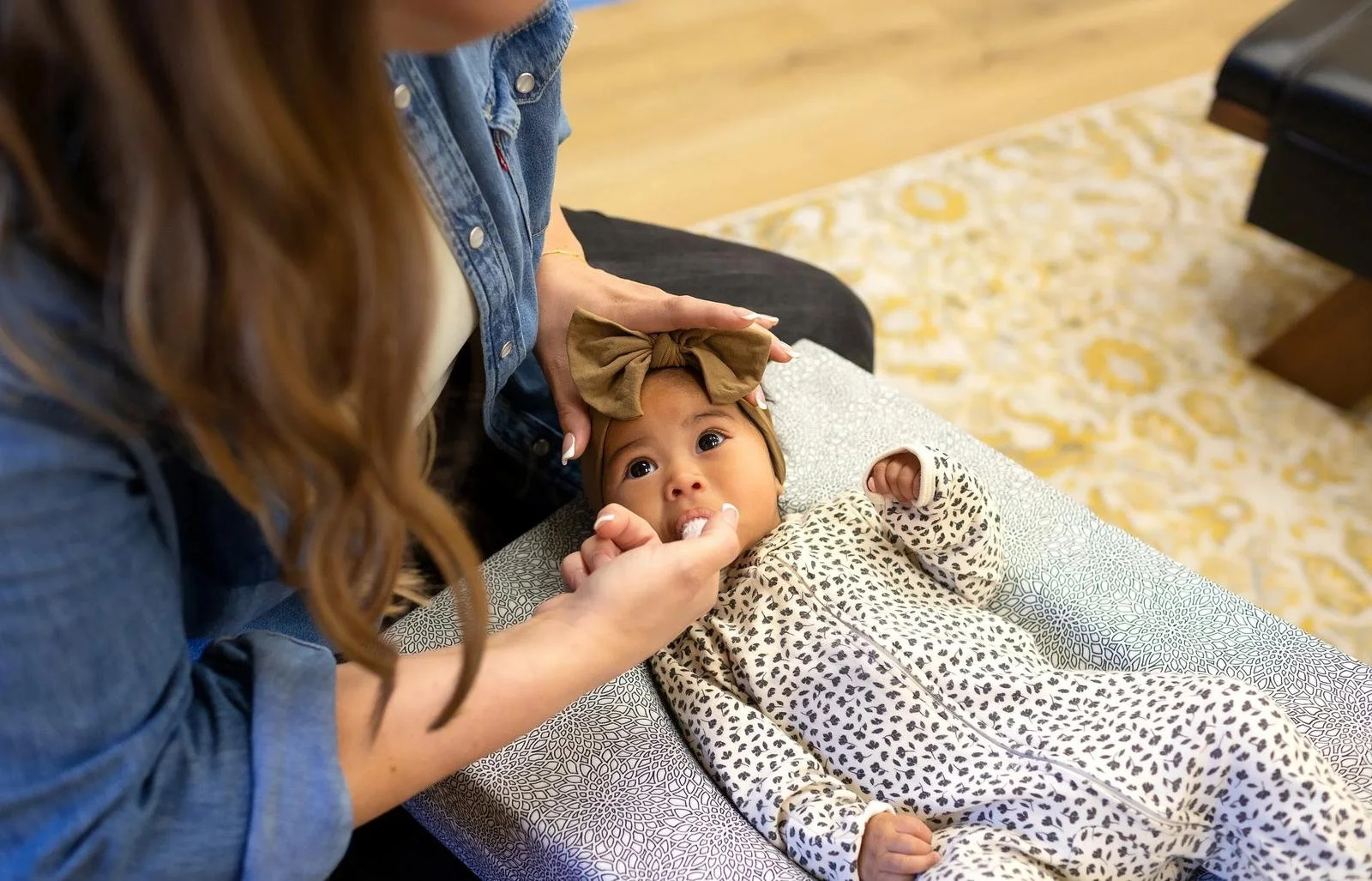 Chiropractor gently supporting an infant’s head during a head and neck assessment at Taproot Chiropractic.