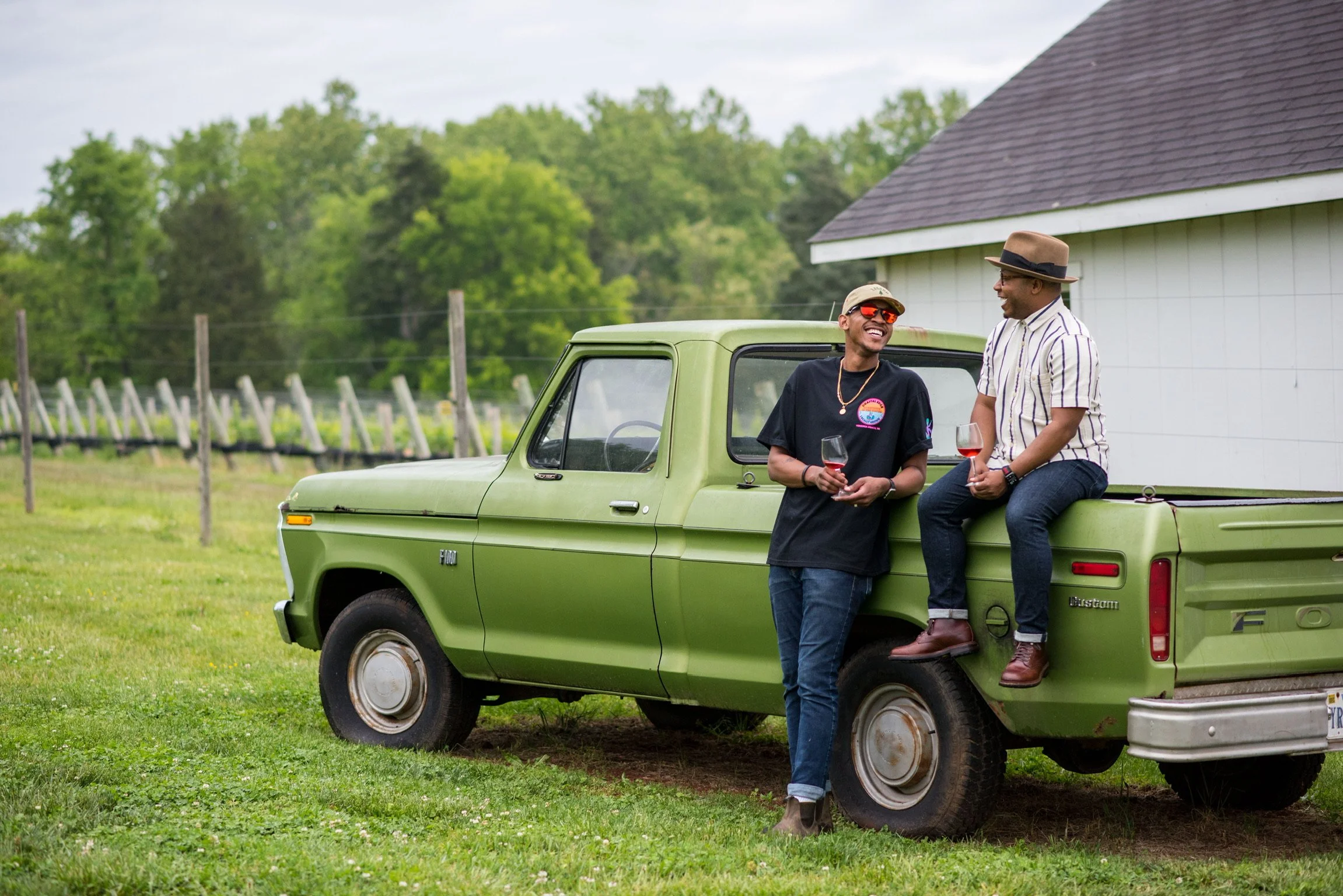Reggie Leonard and winemaking collaborator Lance Lemon talking beside a green vintage truck in a vineyard