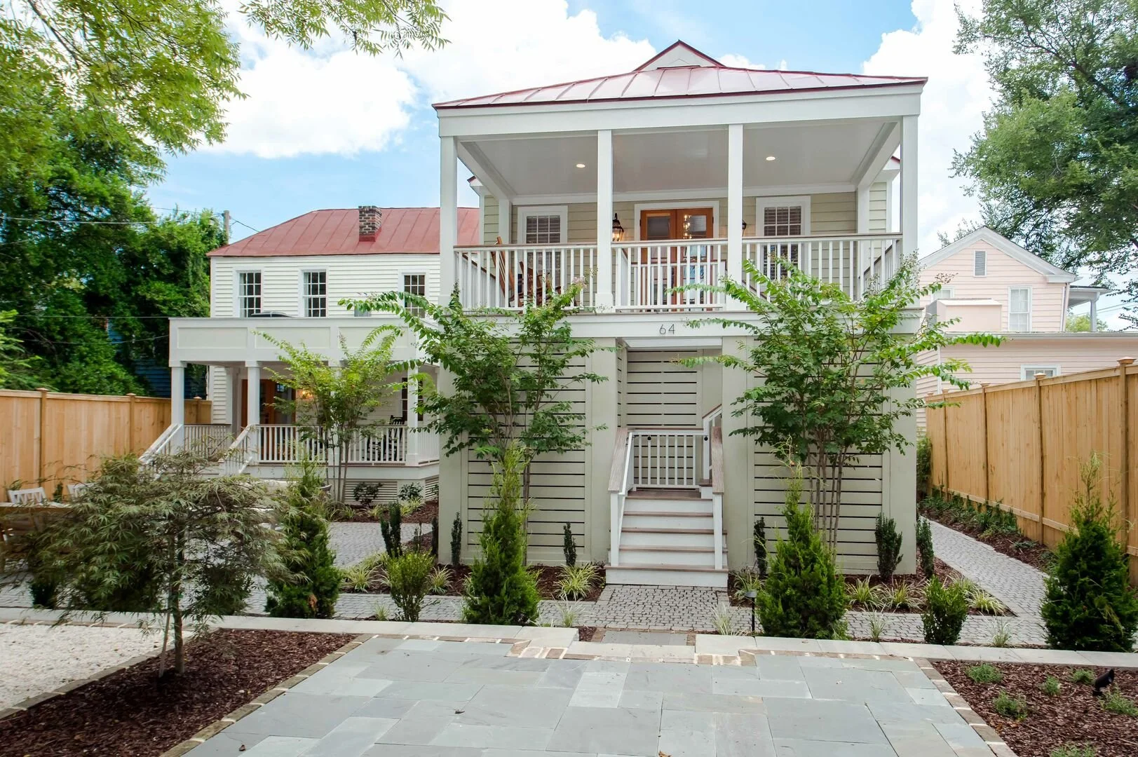 A building surrounded by green hills with snow-capped mountains in the background.