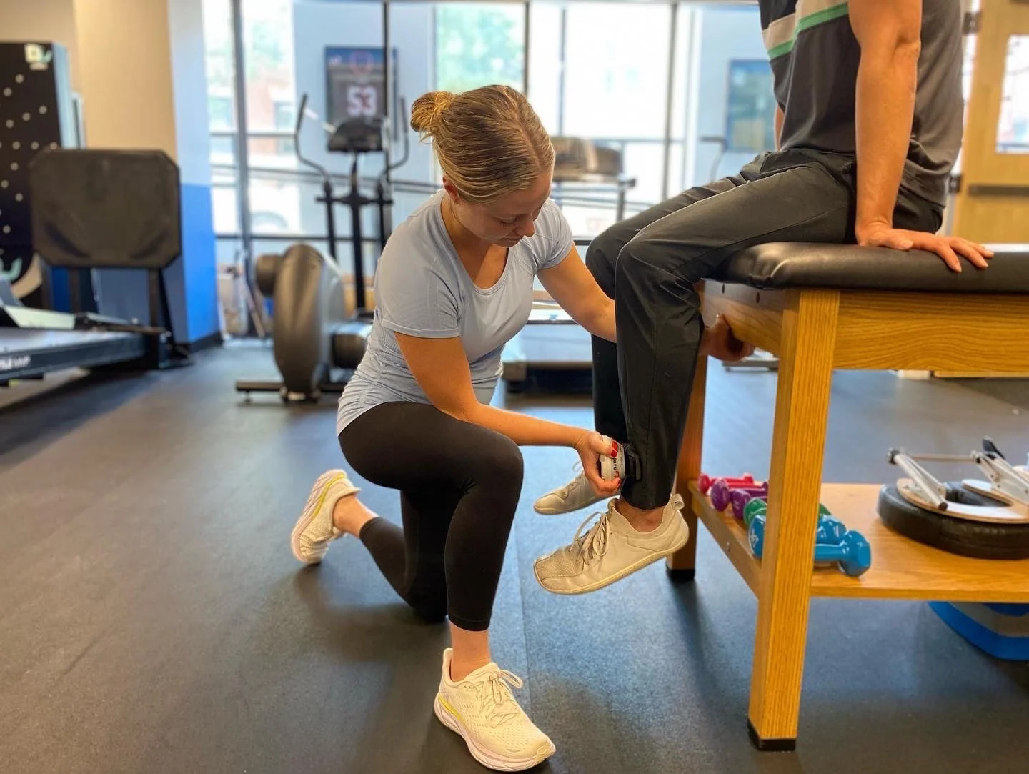 A physical therapist measuring a patient's leg range of motion