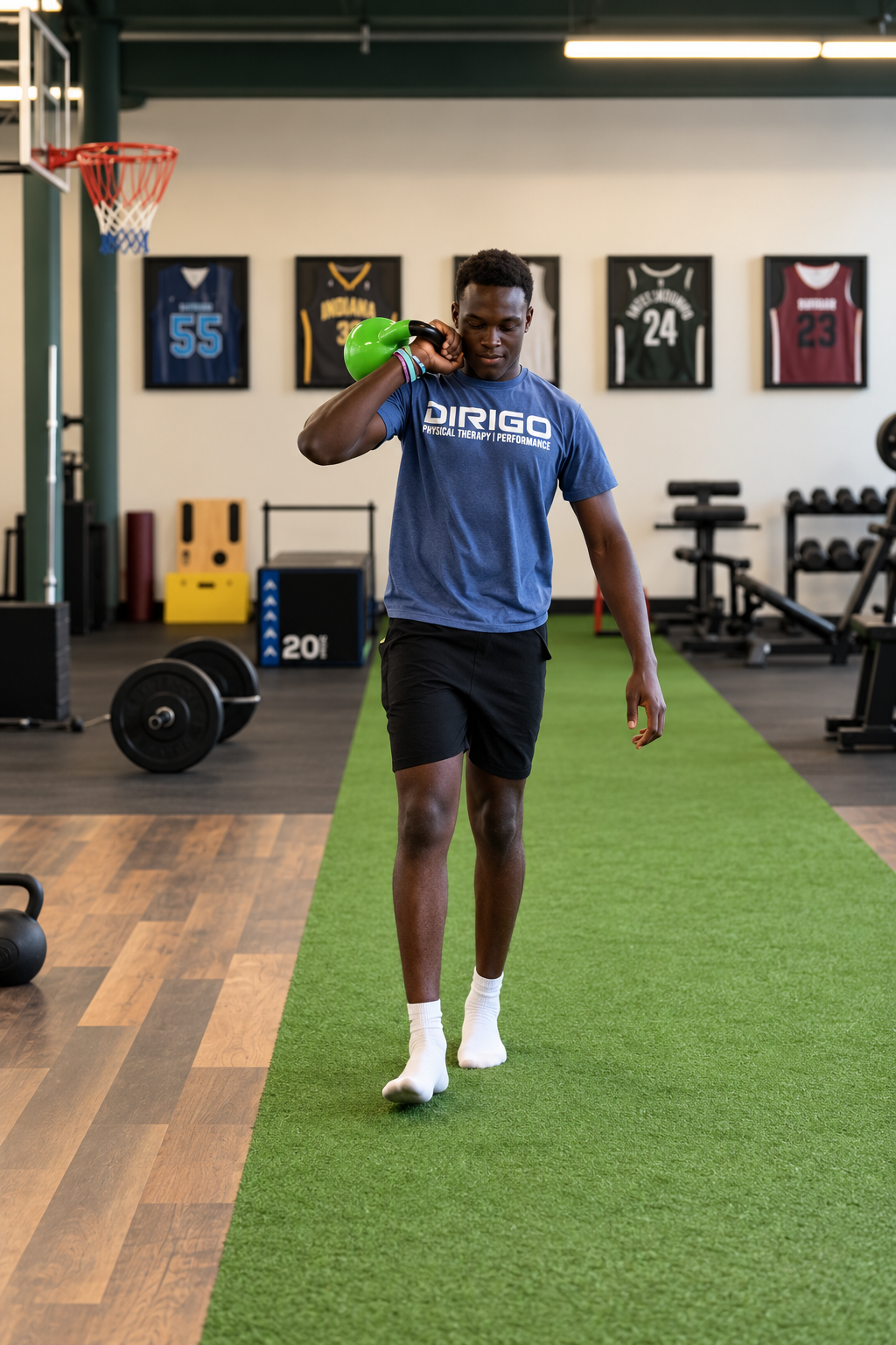 Person preparing to lift a barbell with weight plates in a gym setting.