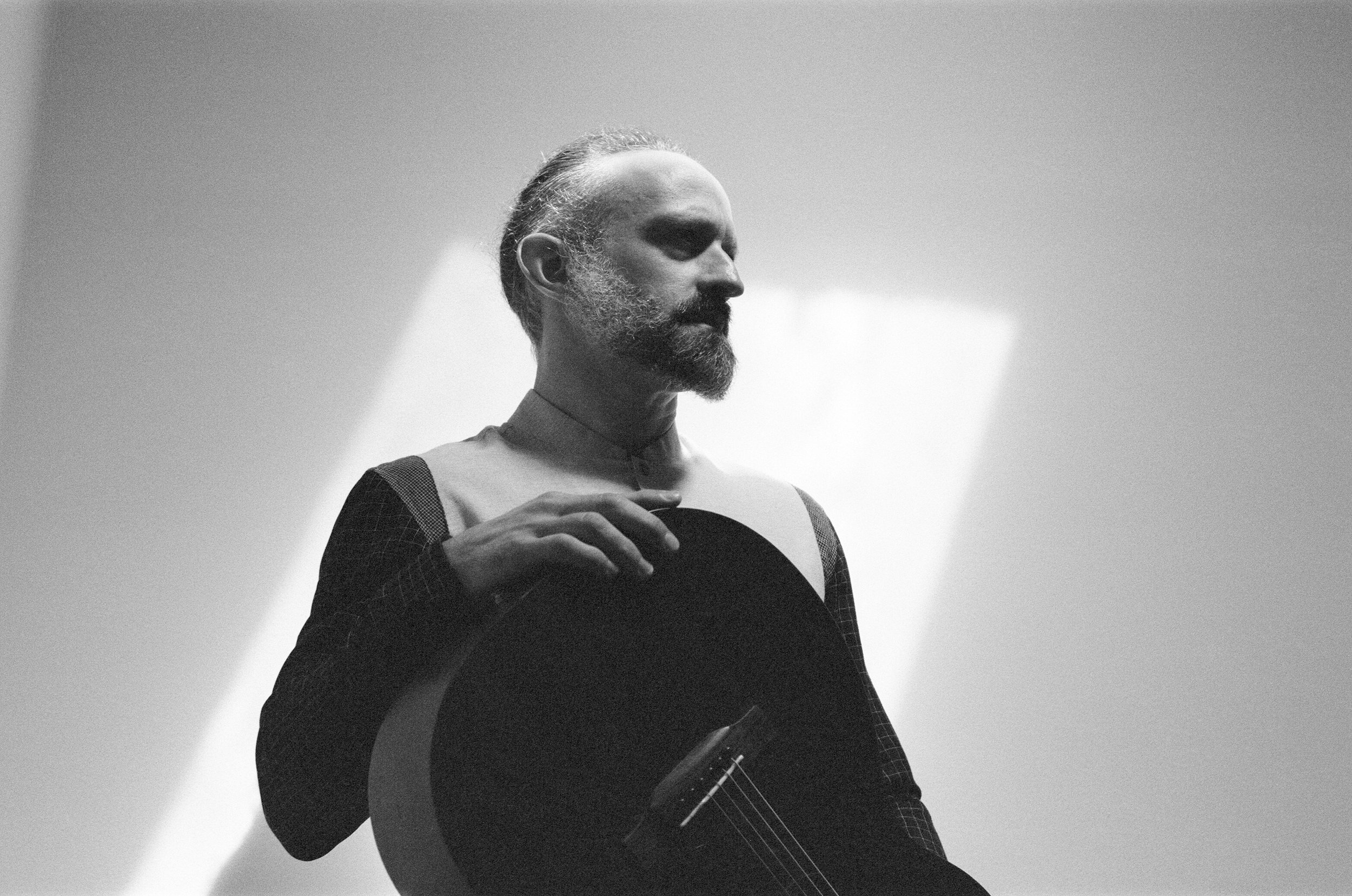 Brian Citro with acoustic guitar in black & white and sunlight.