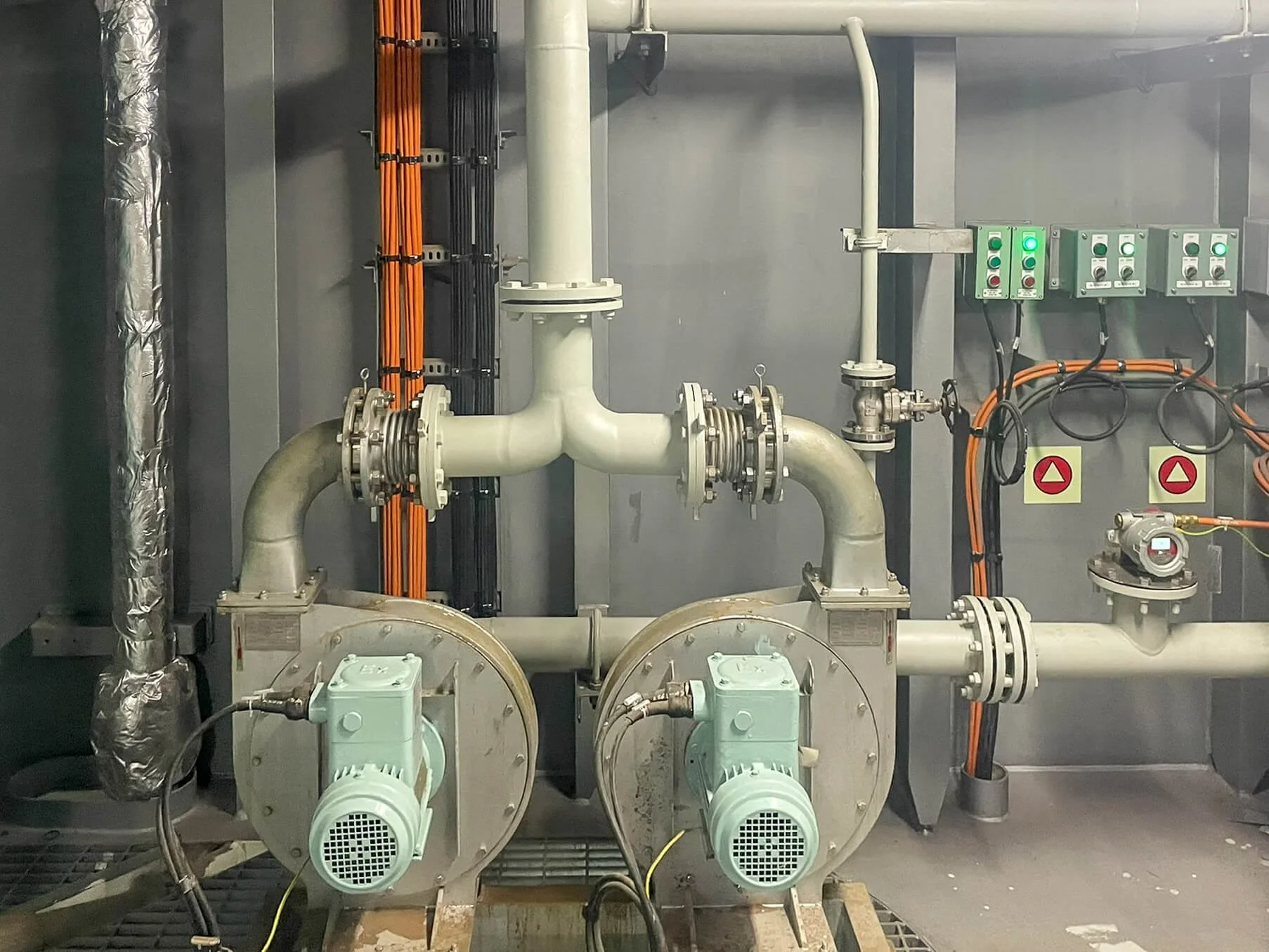 Industrial piping system with large valves, electric motors, and control panels.