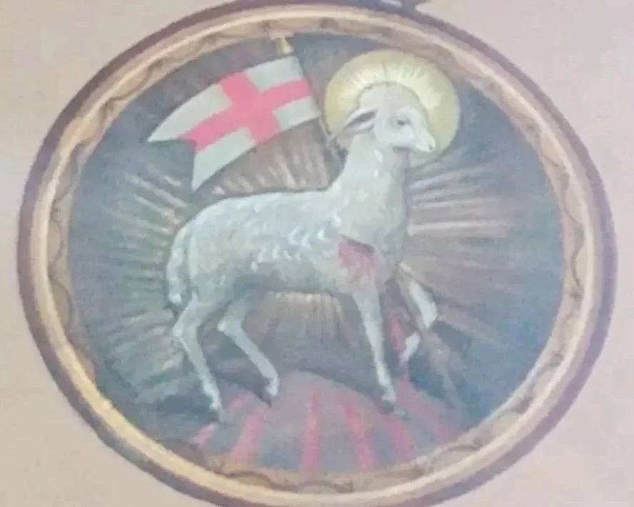 A decorative circular emblem featuring a goat with a halo, a red and white flag, and vibrant colors, possibly representing a cultural or religious symbol.