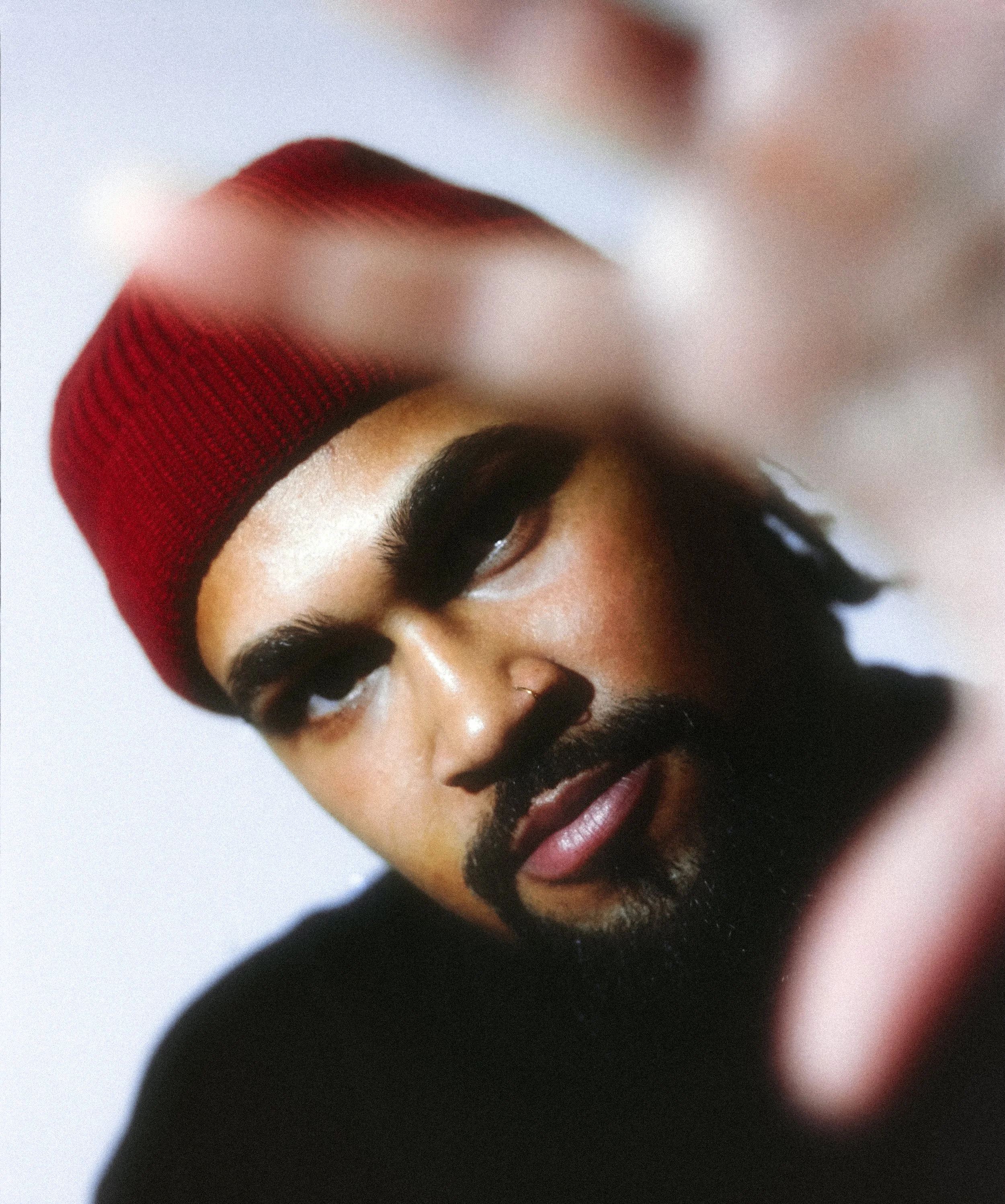 Close-up of a man wearing a red knit beanie