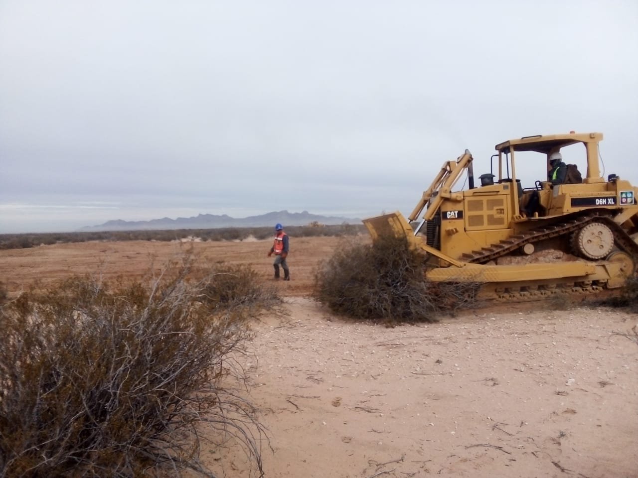 Aude Energía en proyecto Border Solar, motoniveladora trabajando sobre terreno arenoso para nivelación de superficie.
