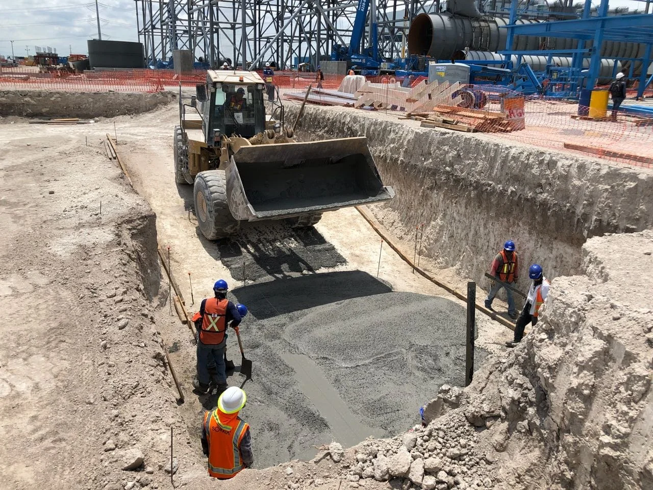 Colocación de concreto en fosa de cimentación con cargadora frontal y personal en obra, El Carmen, NL.