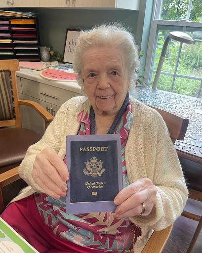 Elderly person holds U.S. passport at assisted living community desk
