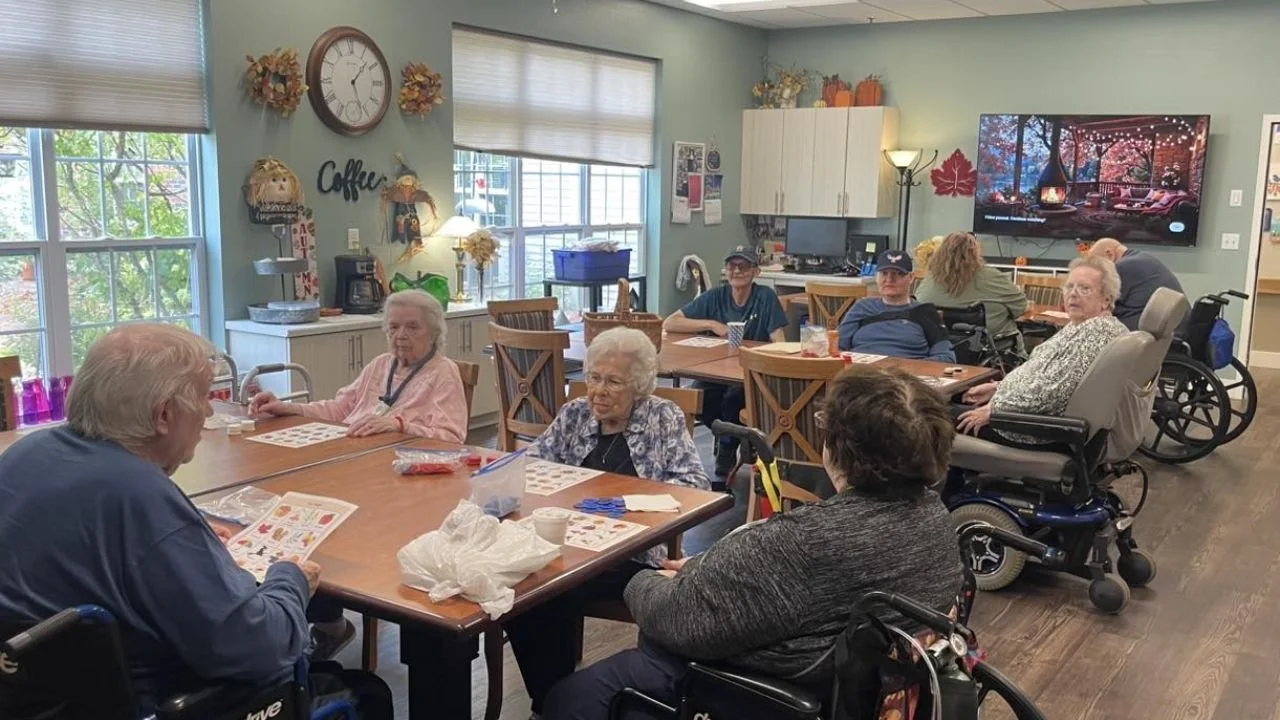 Seniors enjoying autumn craft activity in assisted living. 