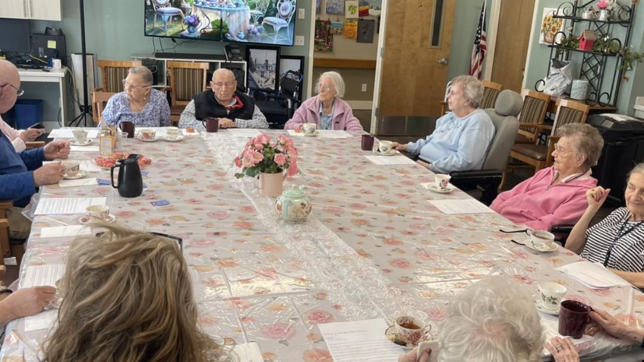 Seniors dining together in assisted living during social tea gathering.