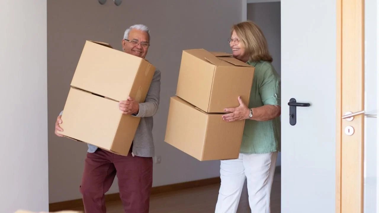 Smiling elderly couple downsizing and moving to an assisted living