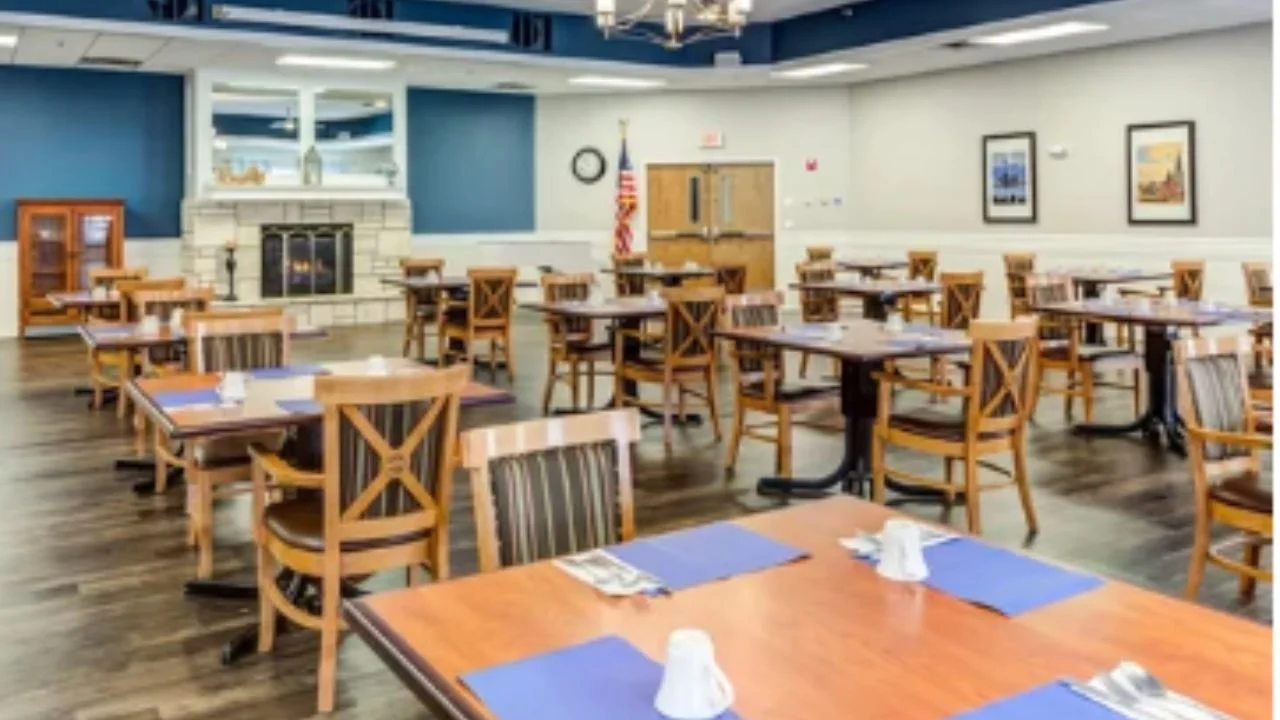 Restaurant-style dining room in assisted living facility with elegant décor and communal tables.