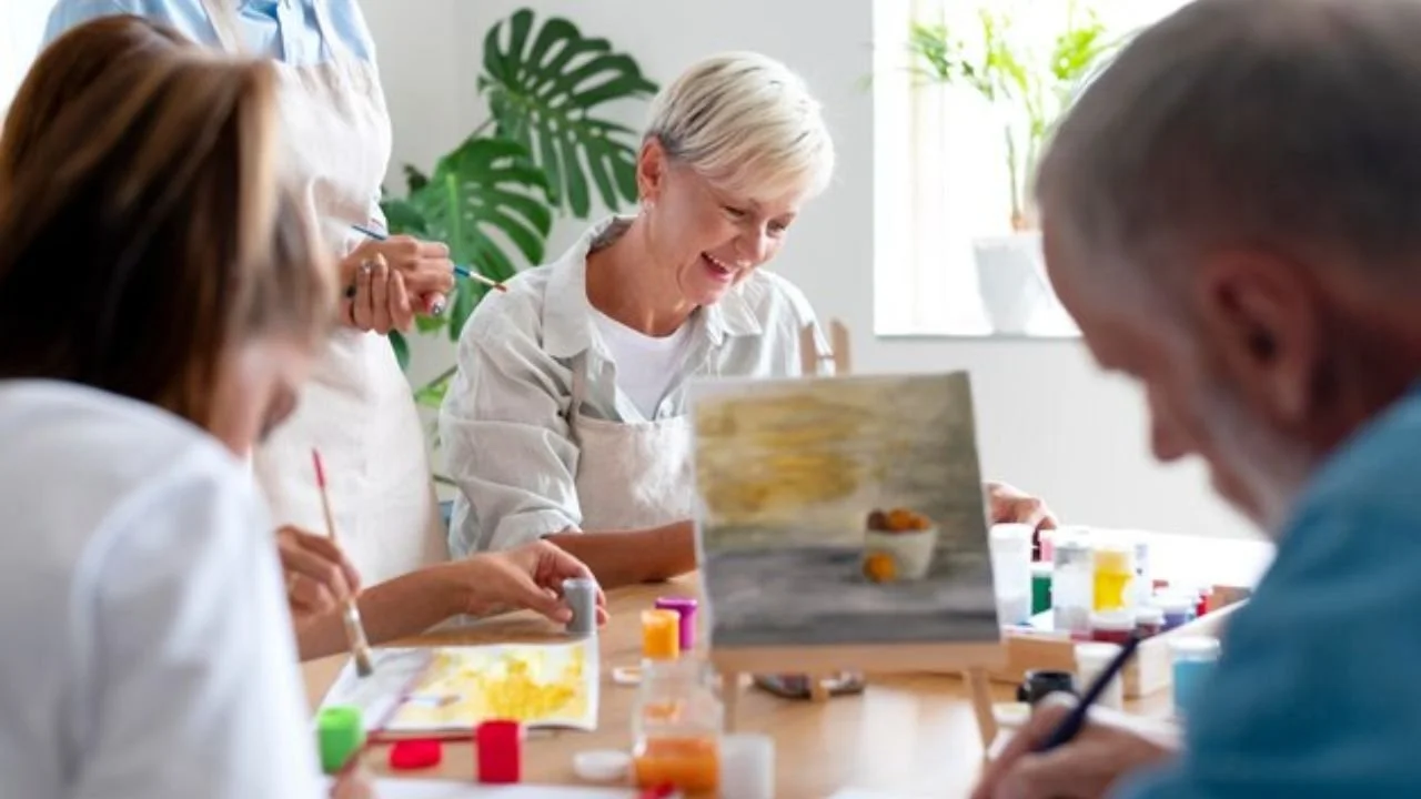 Residents participating in painting activity in an assisted living facility.