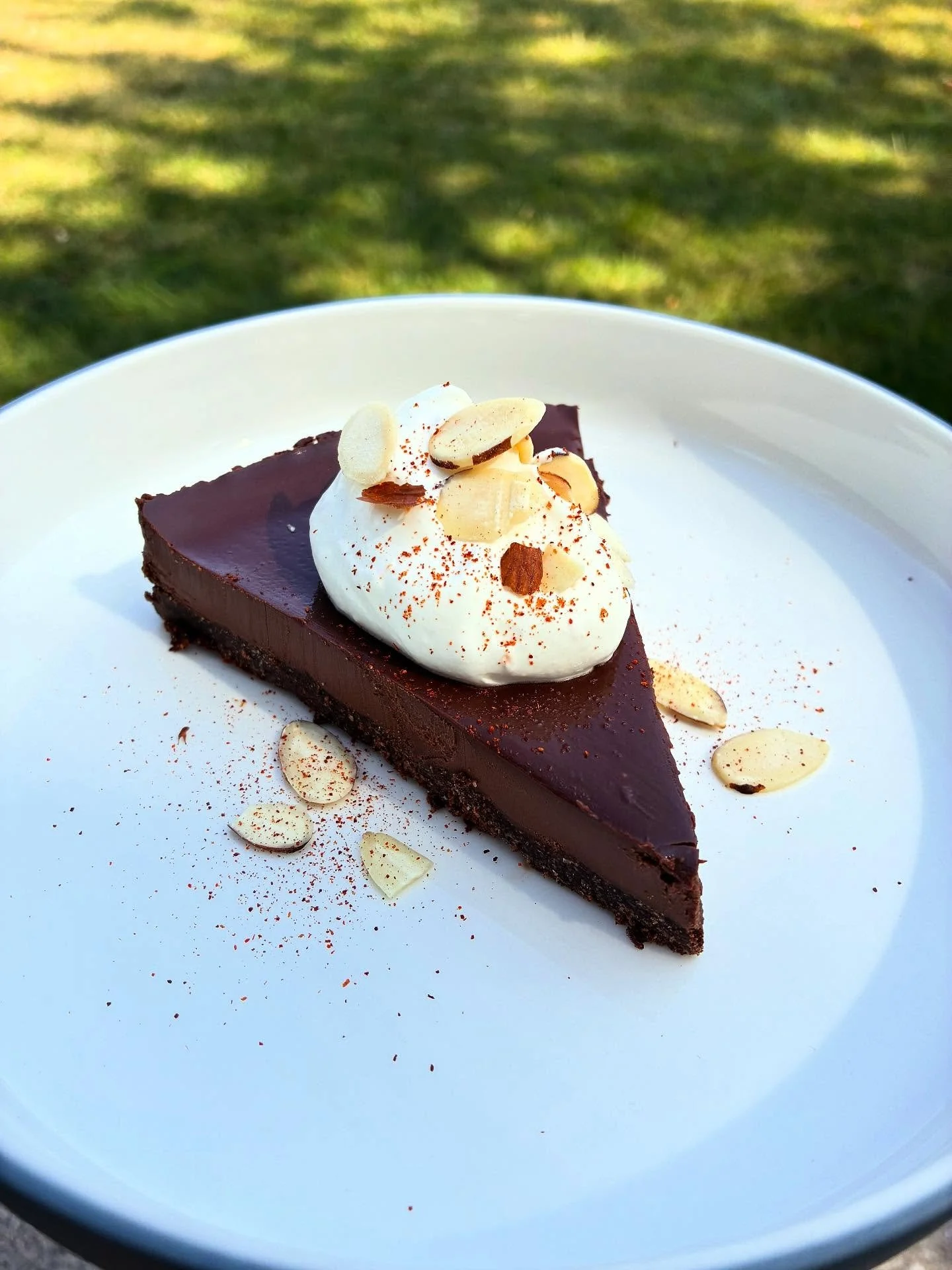 Dark chocolate chili tart 🍫 🌶️ orange whipped cream 🍊slivered almonds ✨