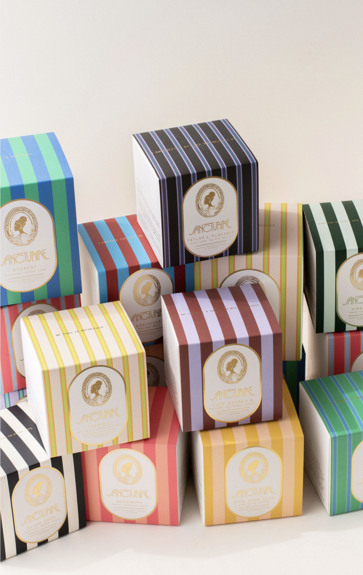 A collection of colorful boxed soaps with striped patterns and gold labels, neatly arranged on a white surface.