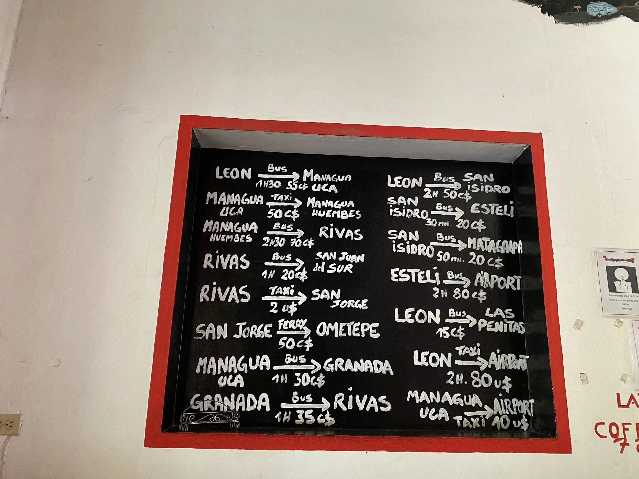 Chalkboard sign showing bus routes and transport prices in Nicaragua including León, Managua, Rivas, and Ometepe