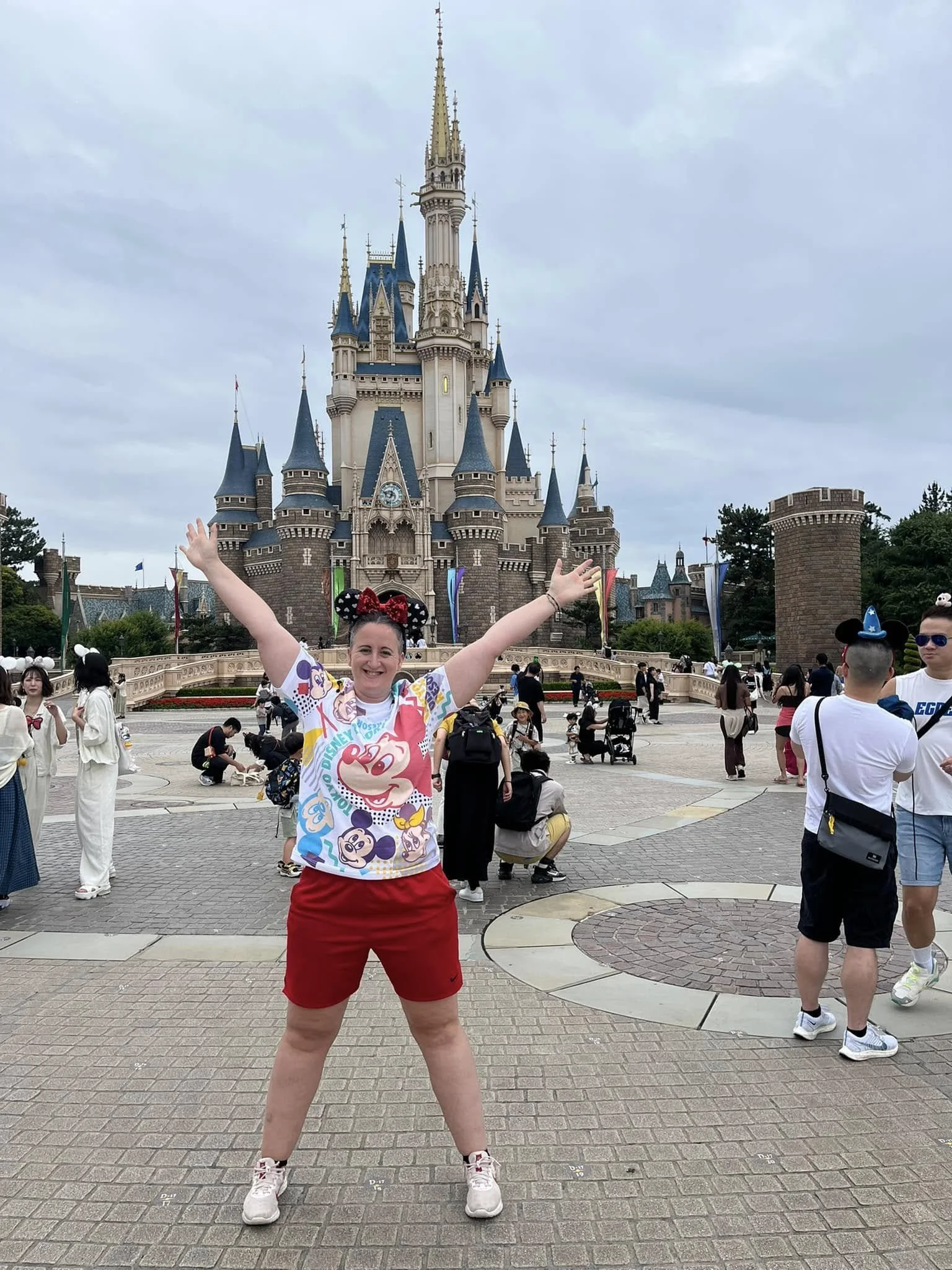 Standing in front of Cinderella Castle at Tokyo Disneyland, celebrating a personal travel goal of visiting Disney parks around the world.