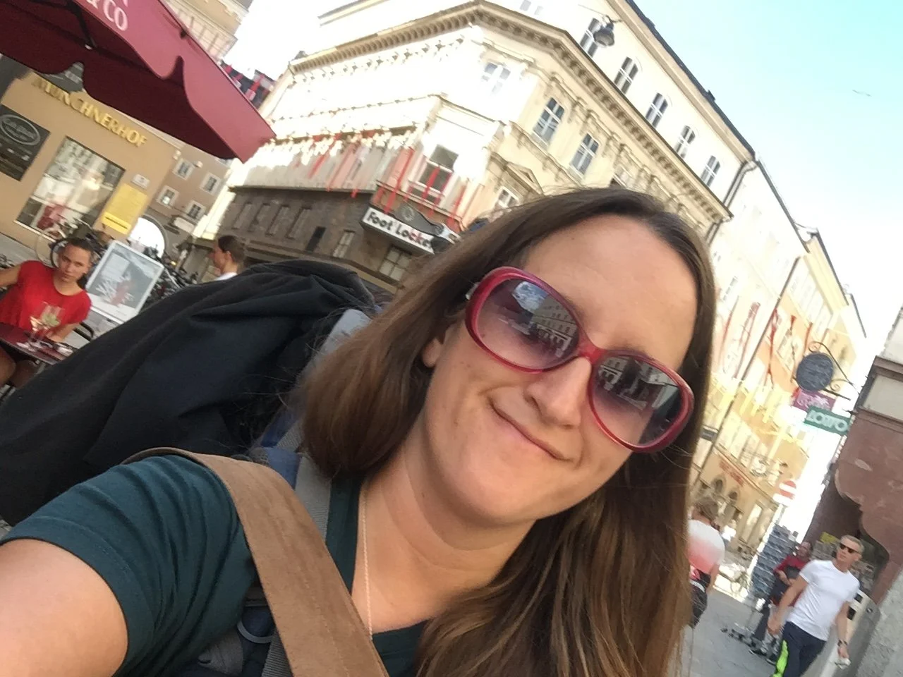 Solo female traveler carrying a large backpack while walking through Salzburg, Austria after accidentally heading in the wrong direction to her hostel.