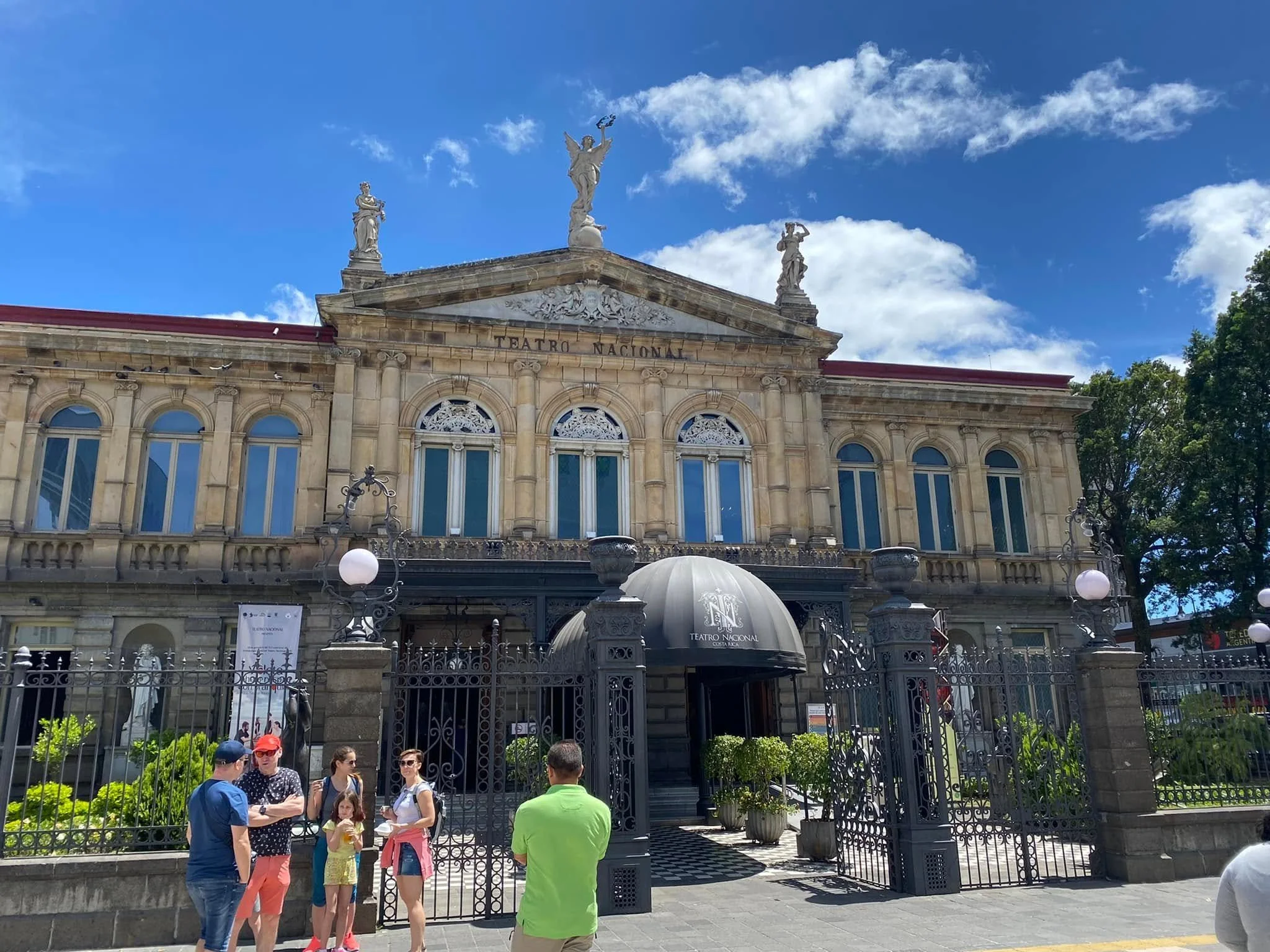 Ornate stone exterior of the National Theatre of Costa Rica under a bright blue sky in San José.