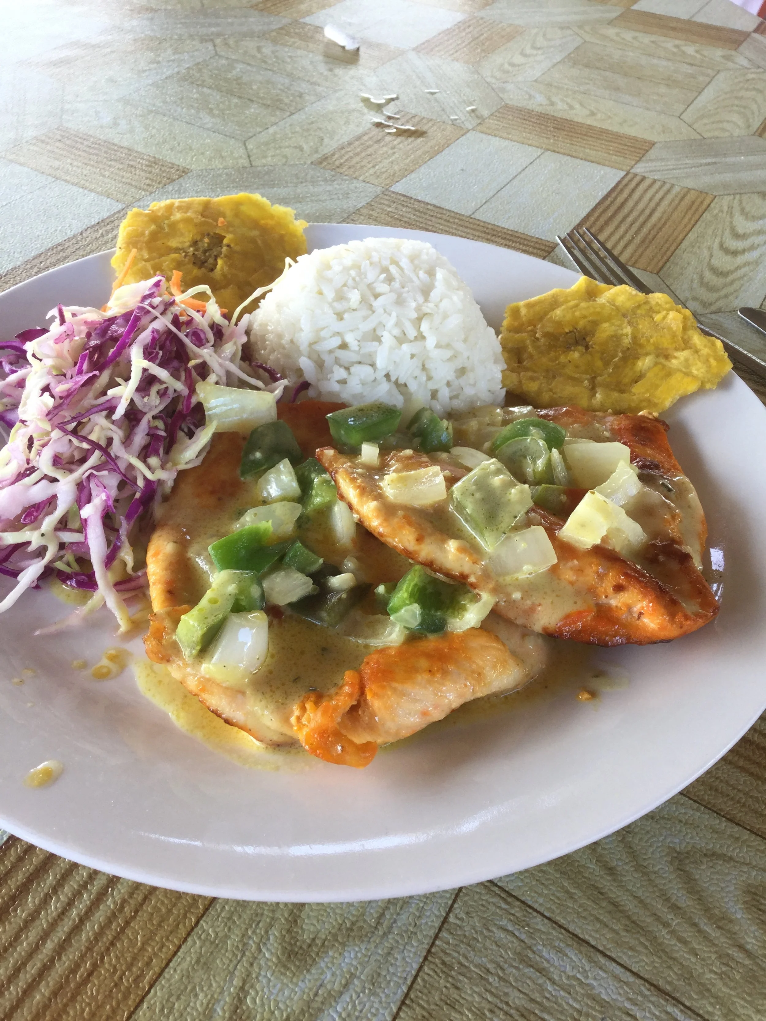 Panamanian meal with chicken, white rice, cabbage slaw and fried plantain patacones.