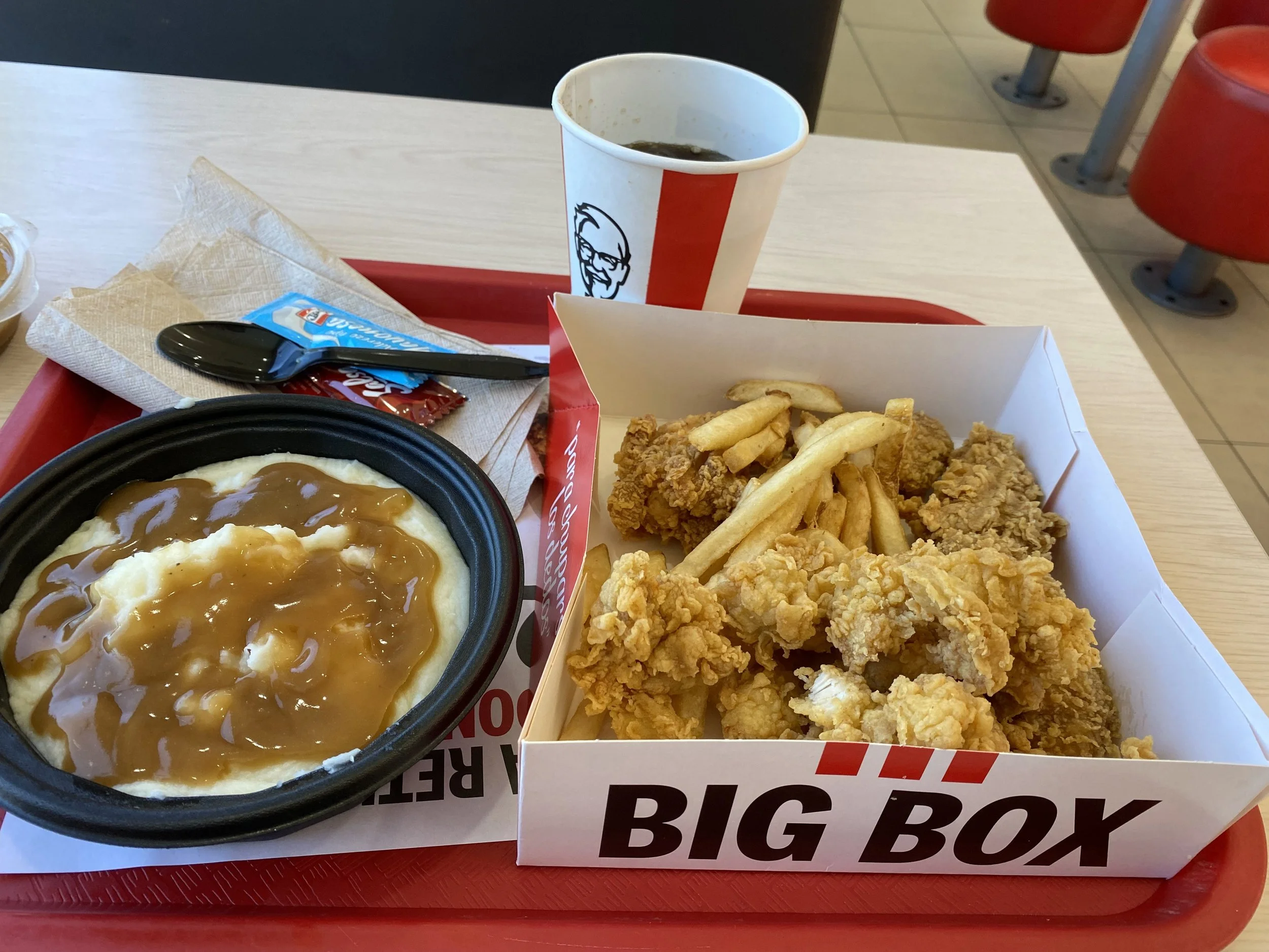 KFC meal with fried chicken, fries, mashed potatoes and gravy on a tray inside a restaurant in Liberia, Costa Rica.