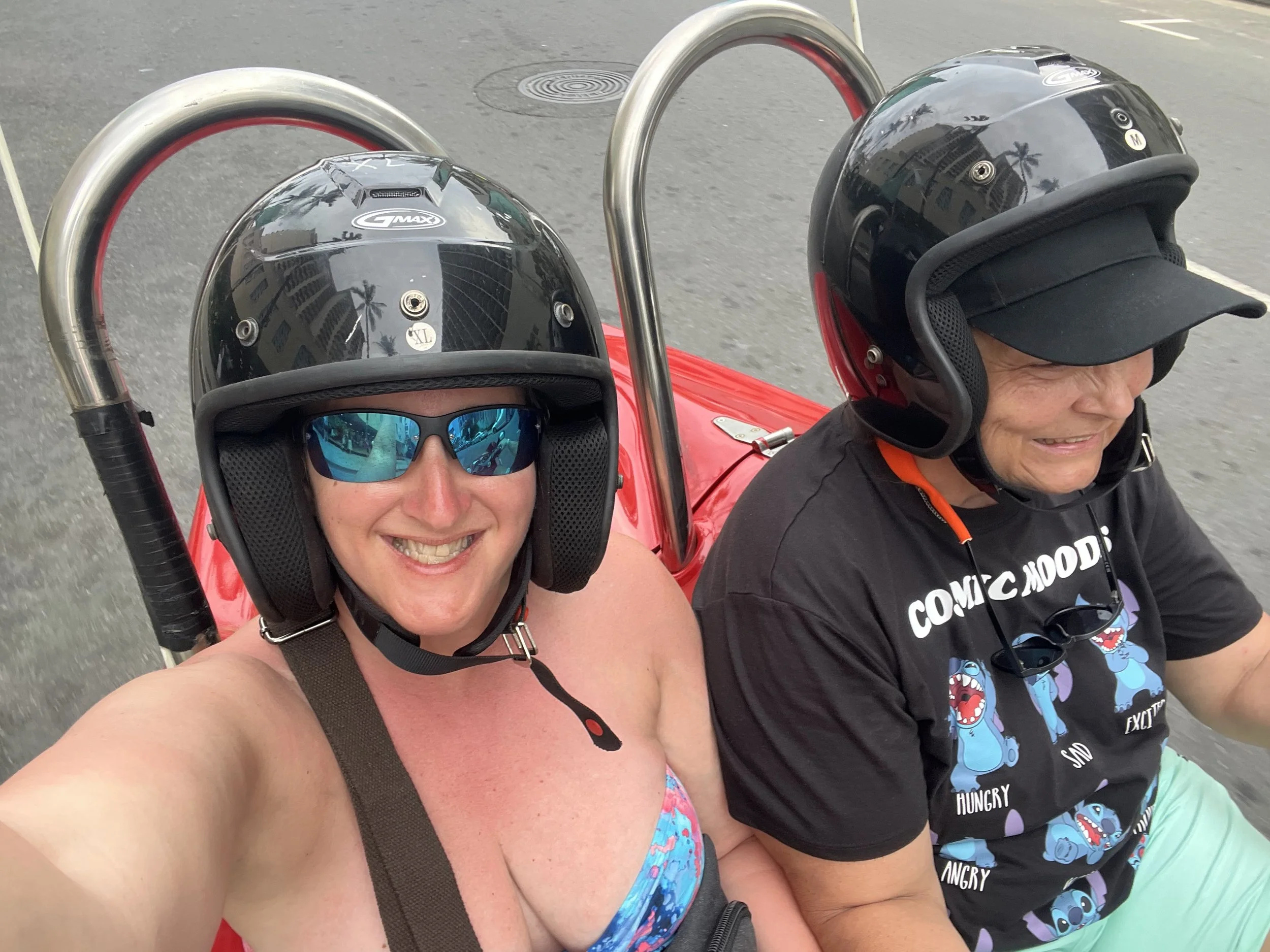 Riding in a small red open-air rental vehicle in Hawaii during a spontaneous adventure before catching a flight home.