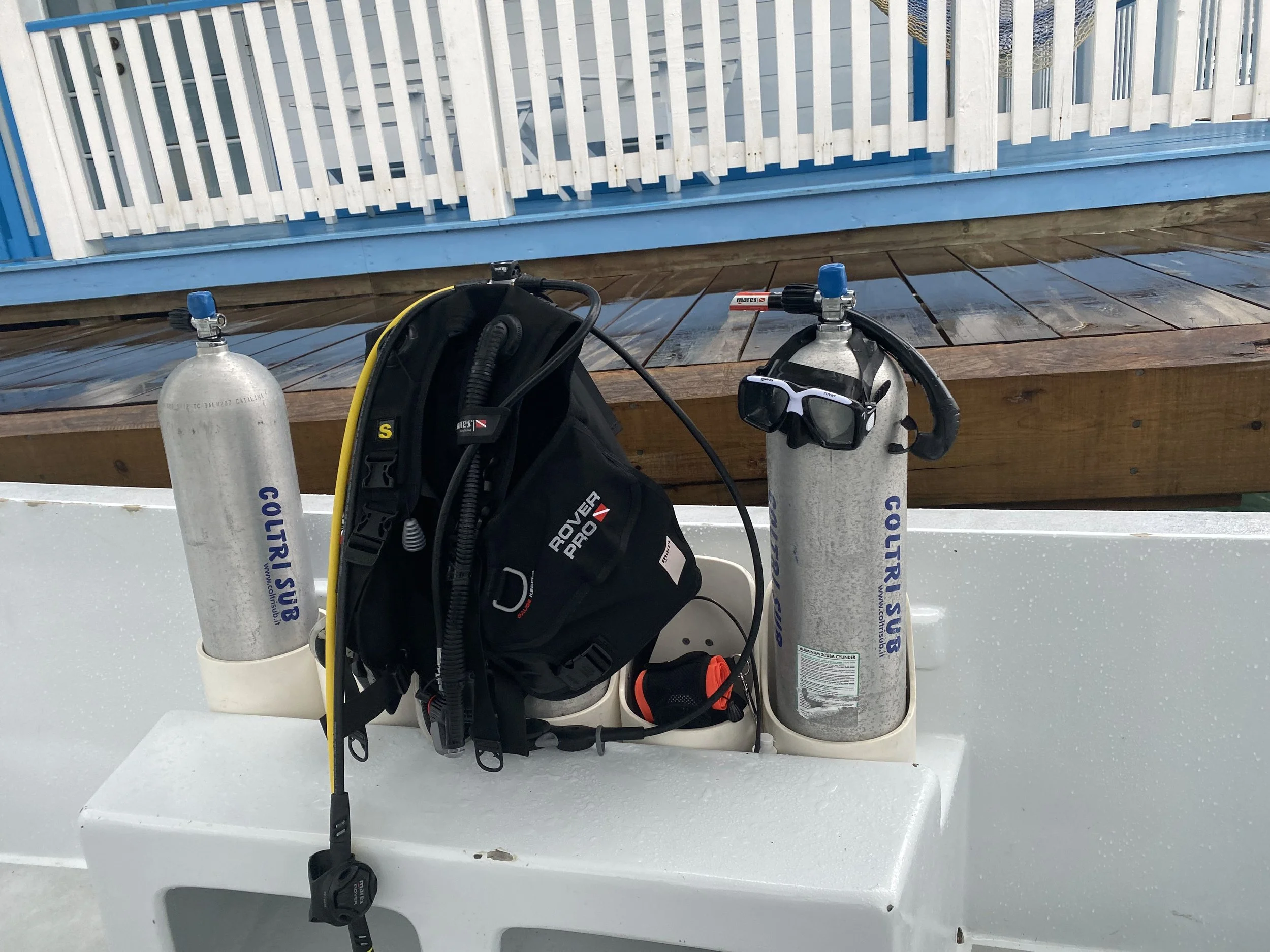 Scuba diving gear and tanks arranged on a dive boat in Utila before the first dive.