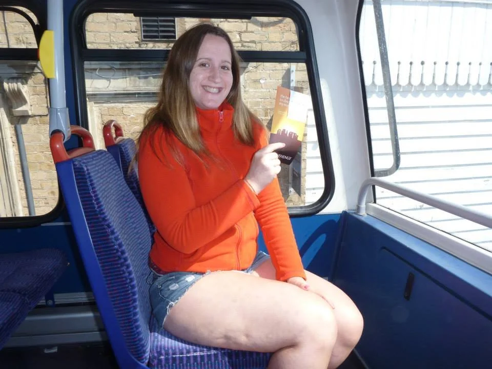 Traveler sitting on a local bus in England while holding a transit ticket on the way to visit Stonehenge.
