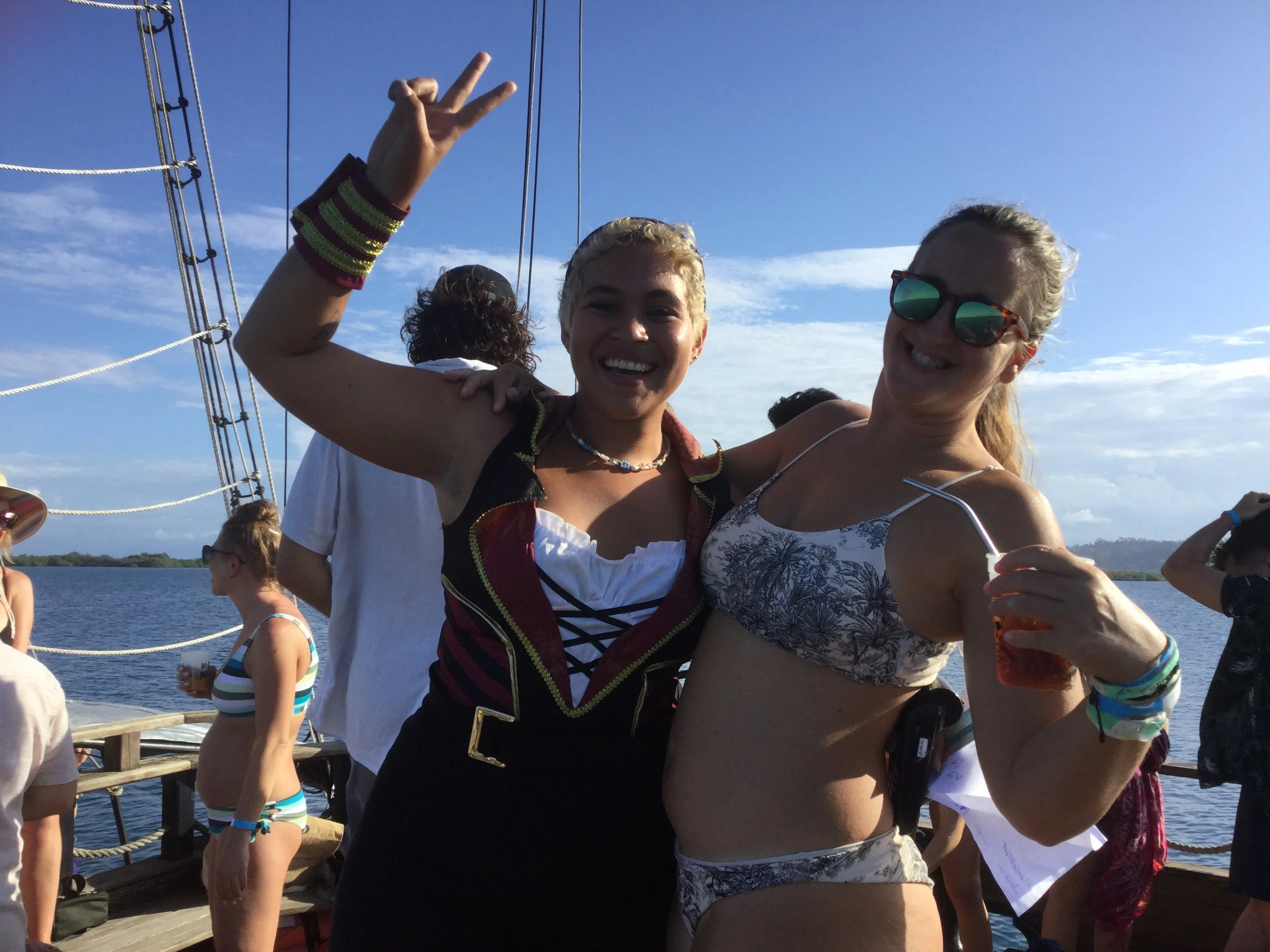 Solo female traveller posing with a pirate ship crew member during a boat party in Bocas del Toro, Panama.