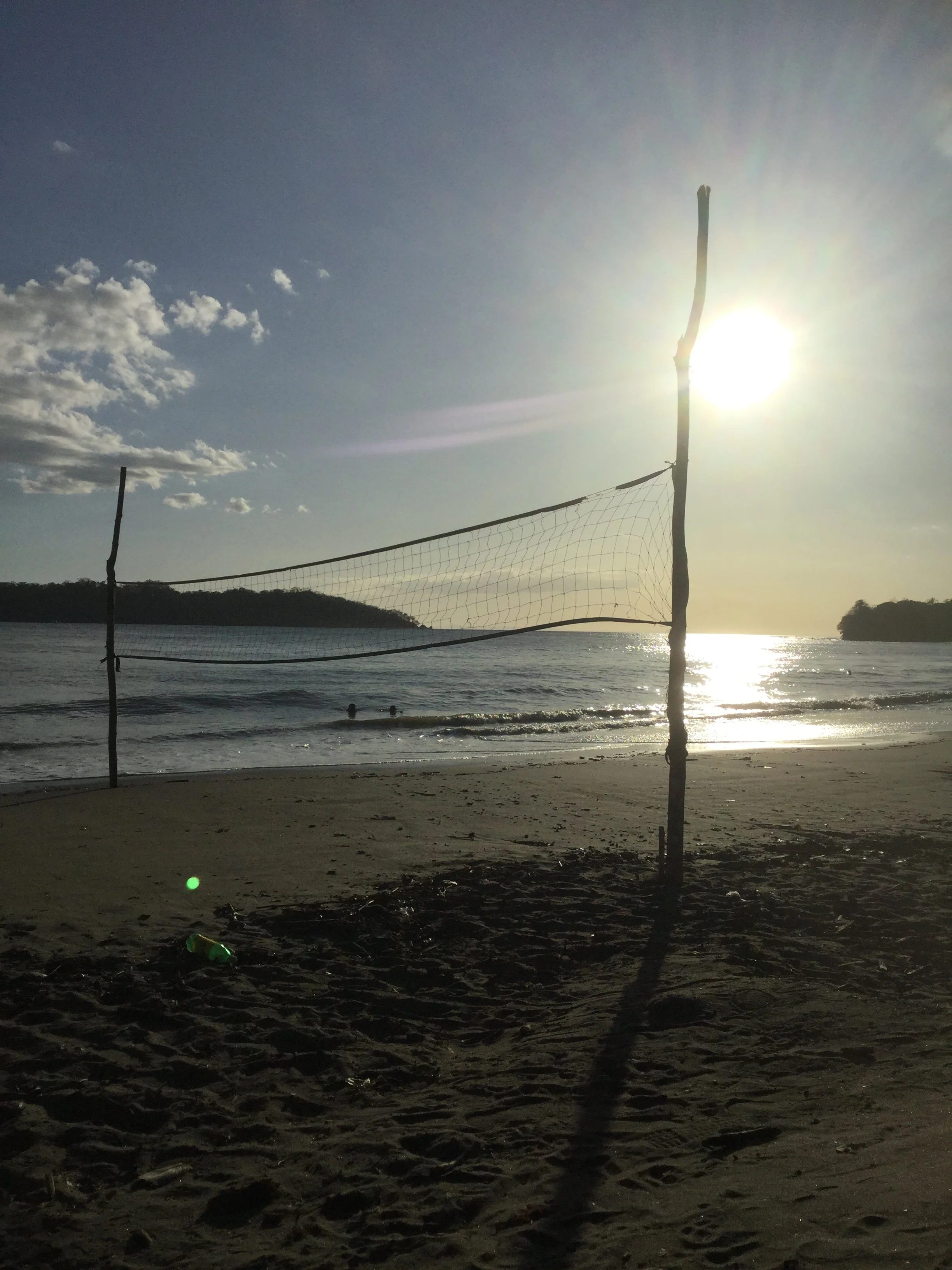 Low sun reflecting across the Pacific Ocean behind a beach volleyball net at Playa Santa Catalina, Panama.