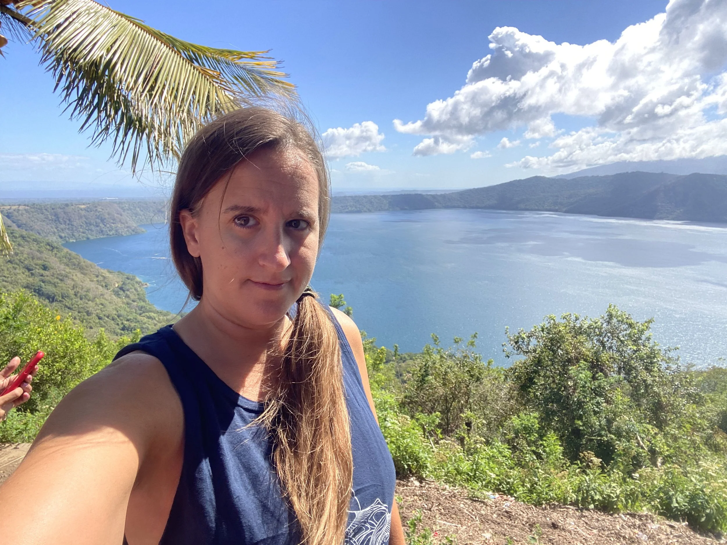 Traveler looking tired and hungover at Laguna de Apoyo viewpoint in Nicaragua with lake view in background