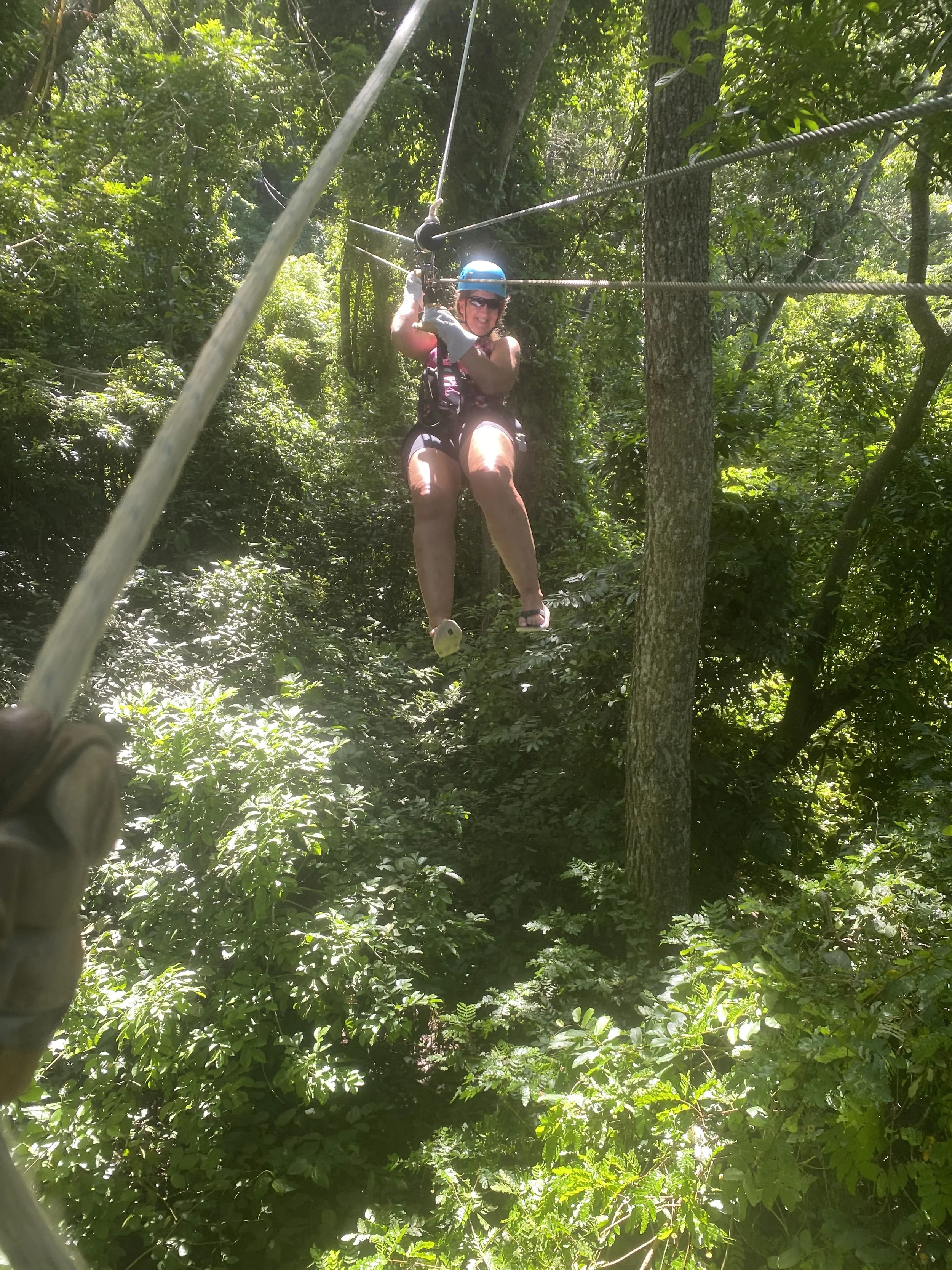Ziplining through tropical jungle at Gumbalimba Park in Roatán, Honduras surrounded by lush forest