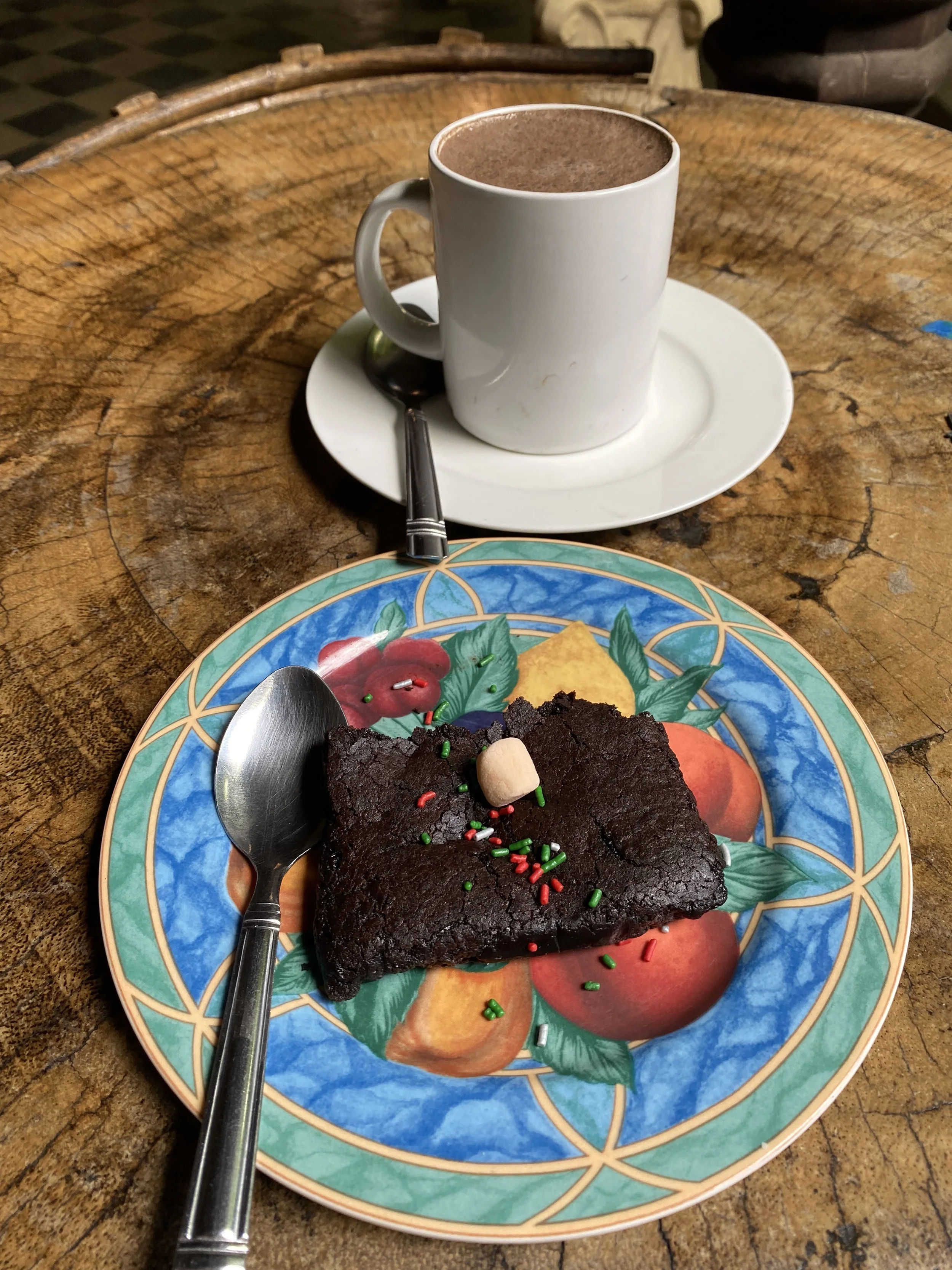 Plate with a chocolate brownie and a cup of hot chocolate on a wooden table inside a café at the Chocolate Museum in Granada, Nicaragua.