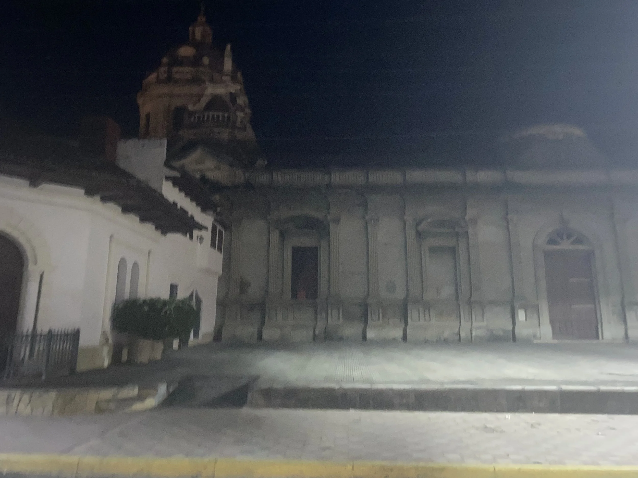 La Merced Church in Granada, Nicaragua at night, with a softly lit façade and bell tower visible in the background.