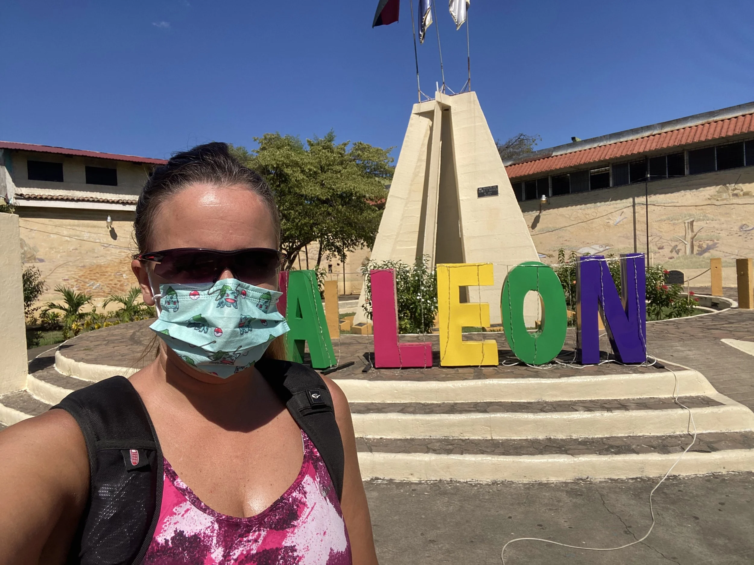 León Nicaragua sign with traveler standing in front on a sunny day
