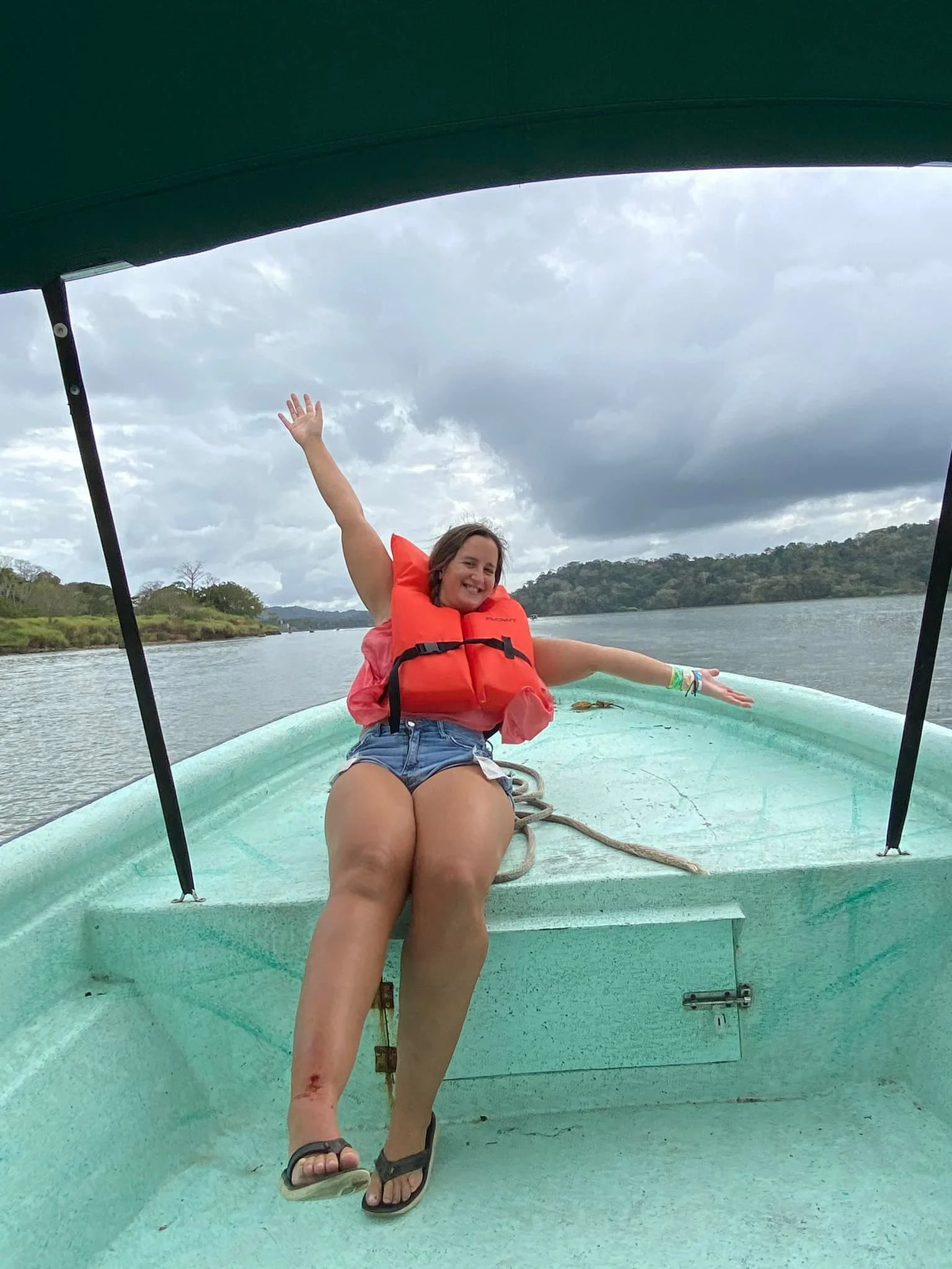 Solo female traveller wearing a life jacket on a small boat travelling across the water in Panama.